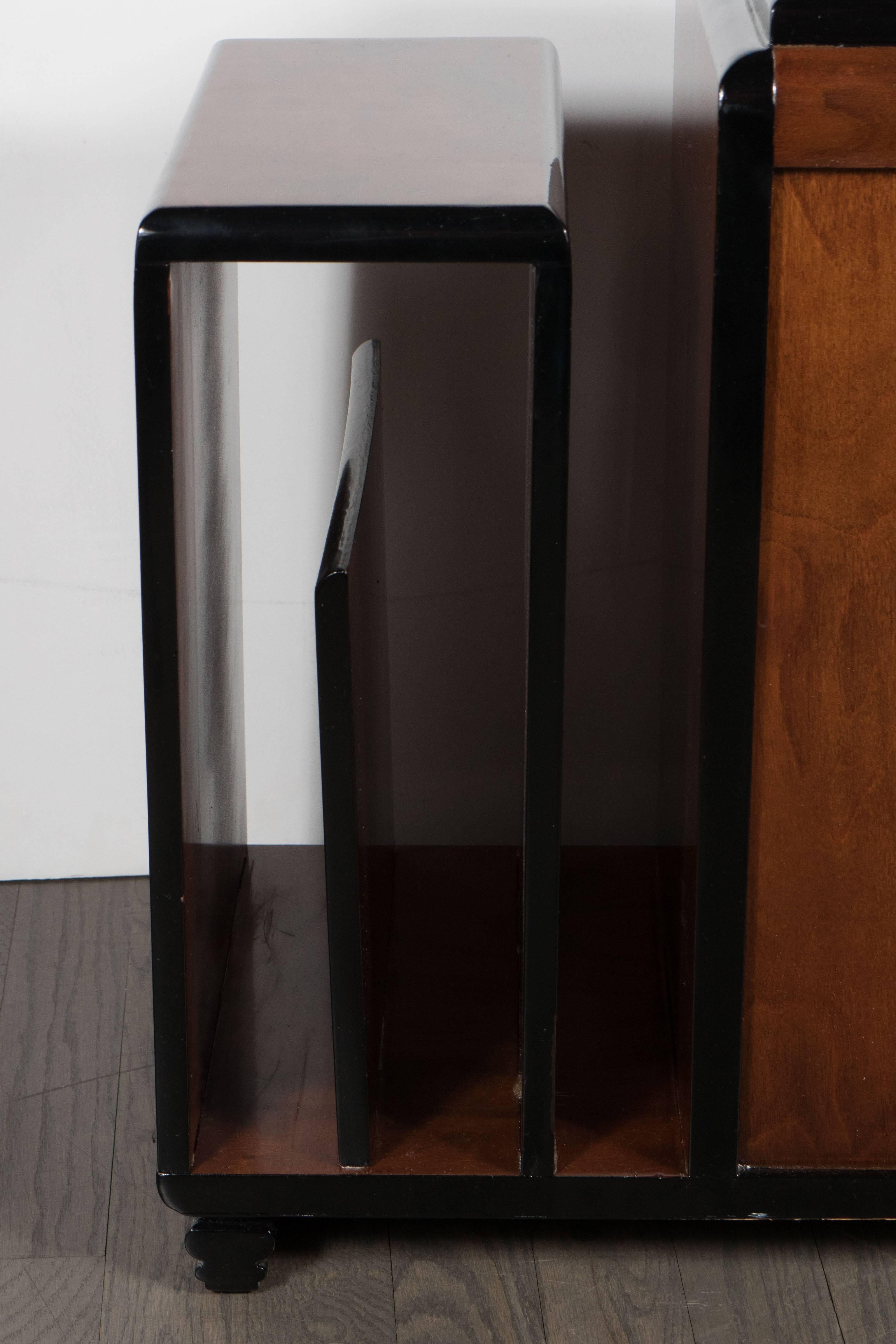 Art Deco walnut and black lacquer magazine or occasional table. A wonderful bookmatched burled walnut covers every exposed surface of the piece. Its front and back feature black lacquer detailing. The piece rests on lacquered feet with