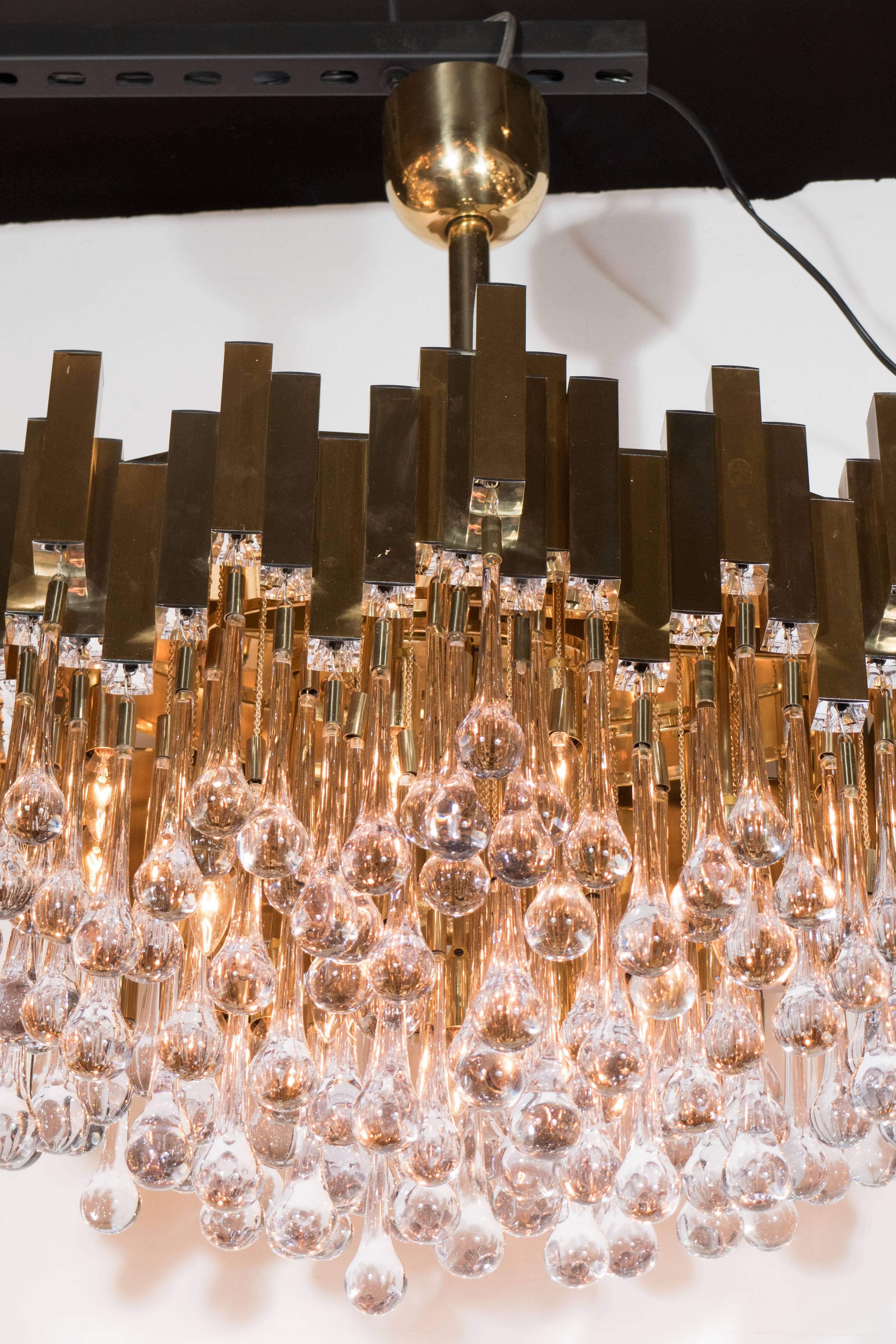 A stunning Mid-Century Modernist chandelier consisting of a rectangular tubed frame of polished and brushed brass with chrome accents above a series of tiers of crystal 