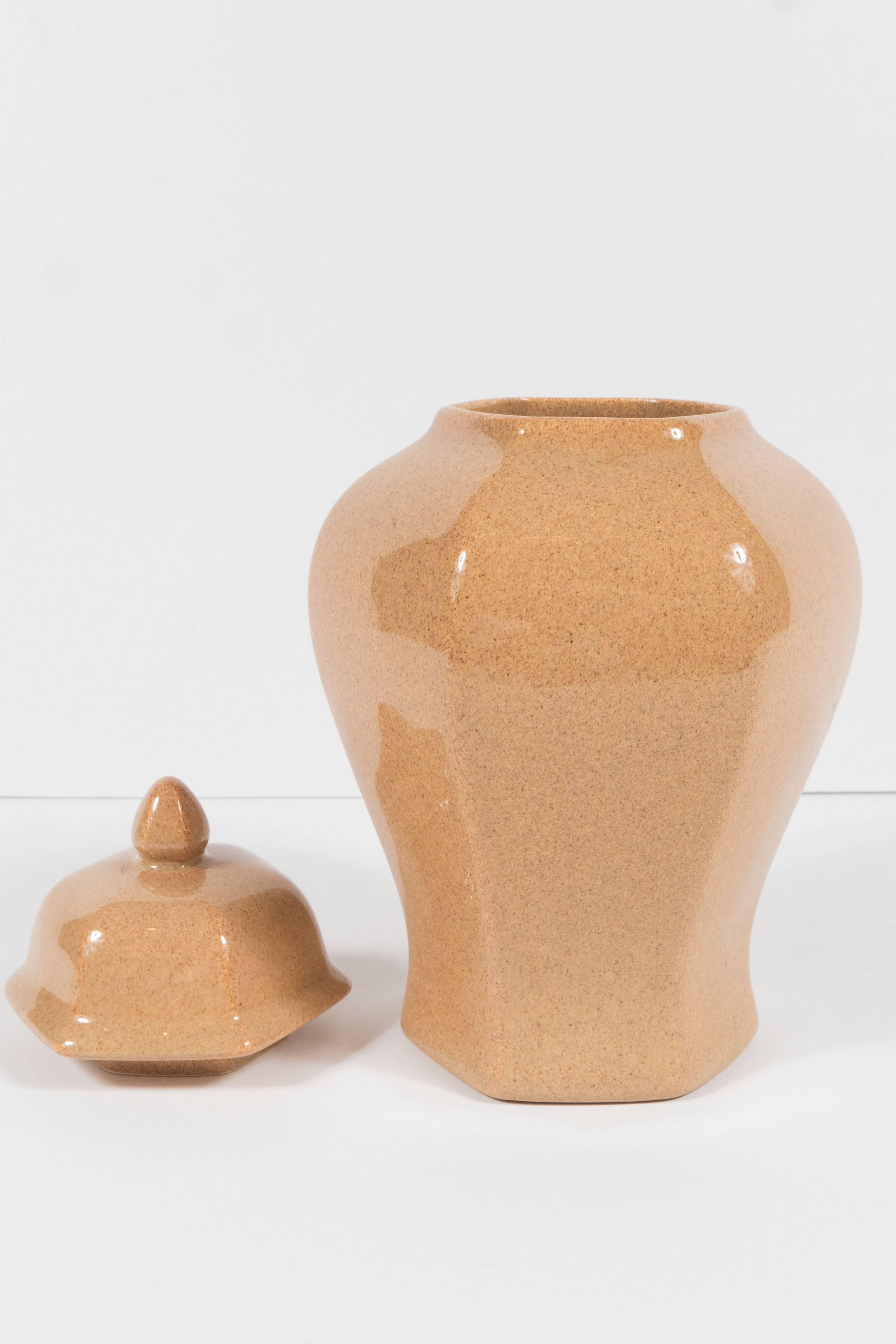 This rounded hexagonal form stylized ginger jar has a beautiful sand colored glaze and is signed Tiffany on the bottom . It is a great accessory piece that would style in well with any decor. It is in mint condition.