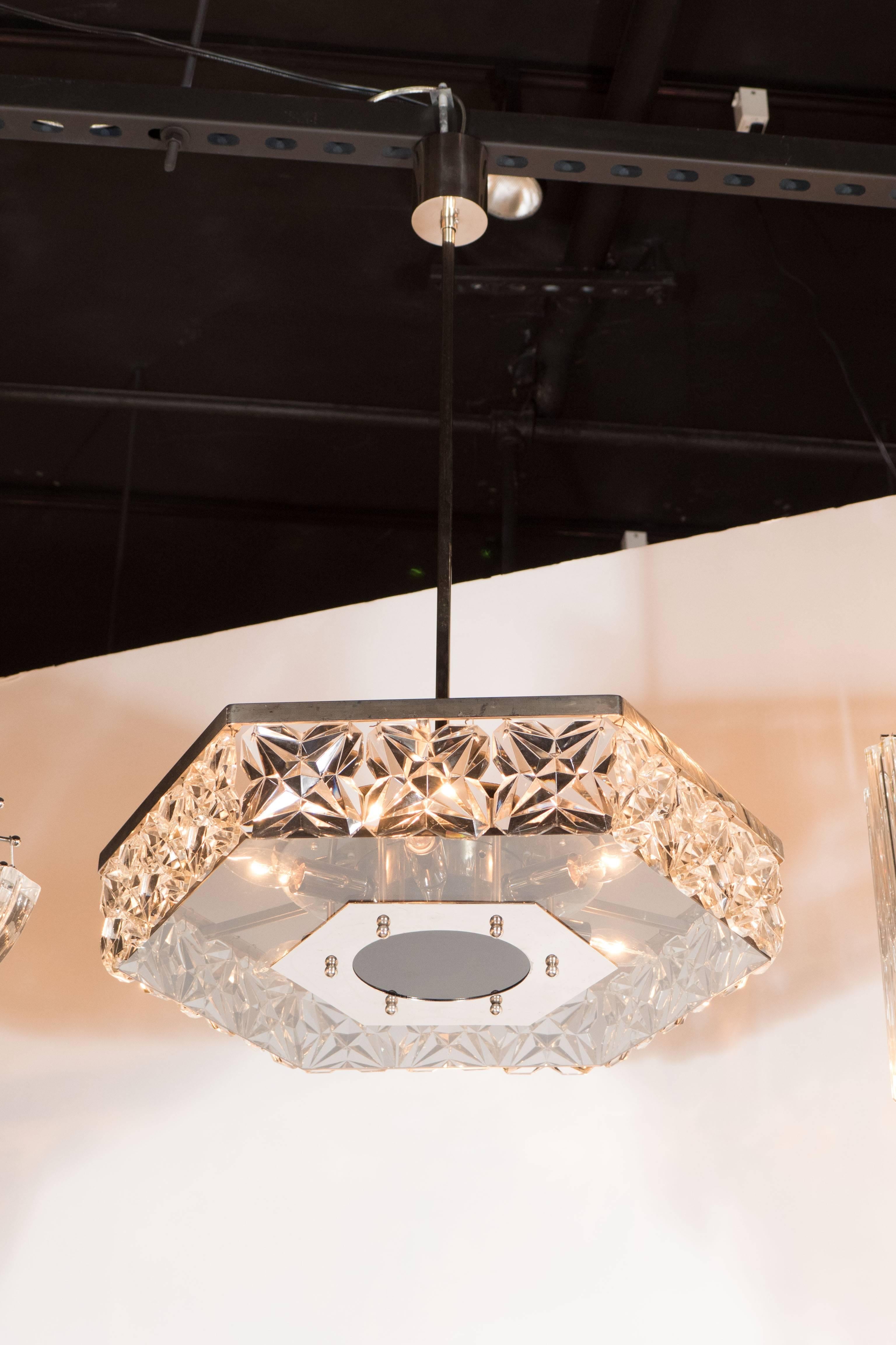Mid-Century modernist faceted crystal chandelier in hexagonal form by Kinkeldey. Squares of hand-cut faceted crystals rest side by side, supported by central chrome ball fittings, in a hexagonal, single tiered concession. The piece is banded with