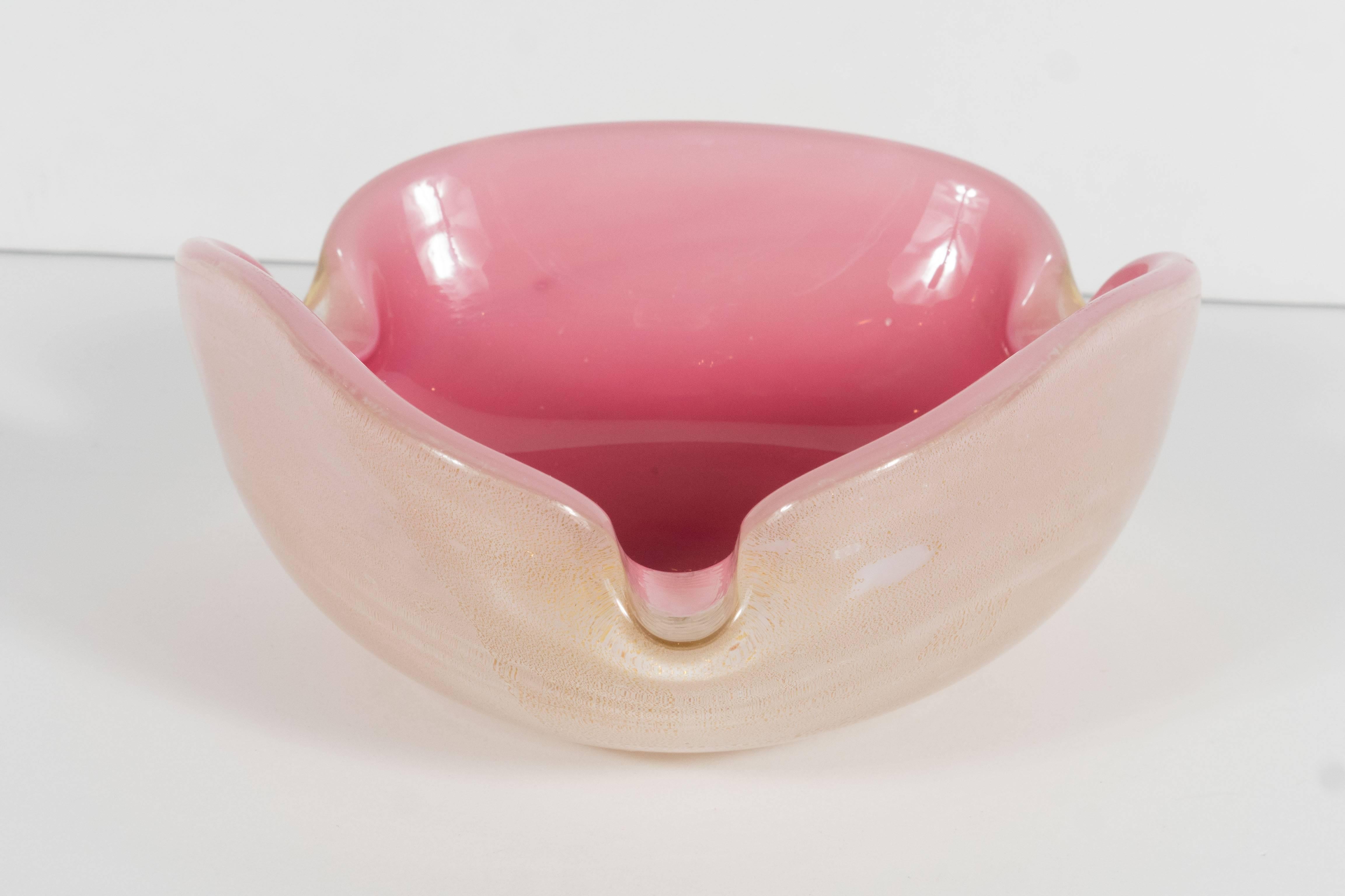 A handblown Murano three-sided glass ashtray. Its interior features a lovely gradient of rich pink in the center softening as it reaches the outer edges. The outer side of the bowl features swirls of 24-karat yellow gold. The exterior is a soft