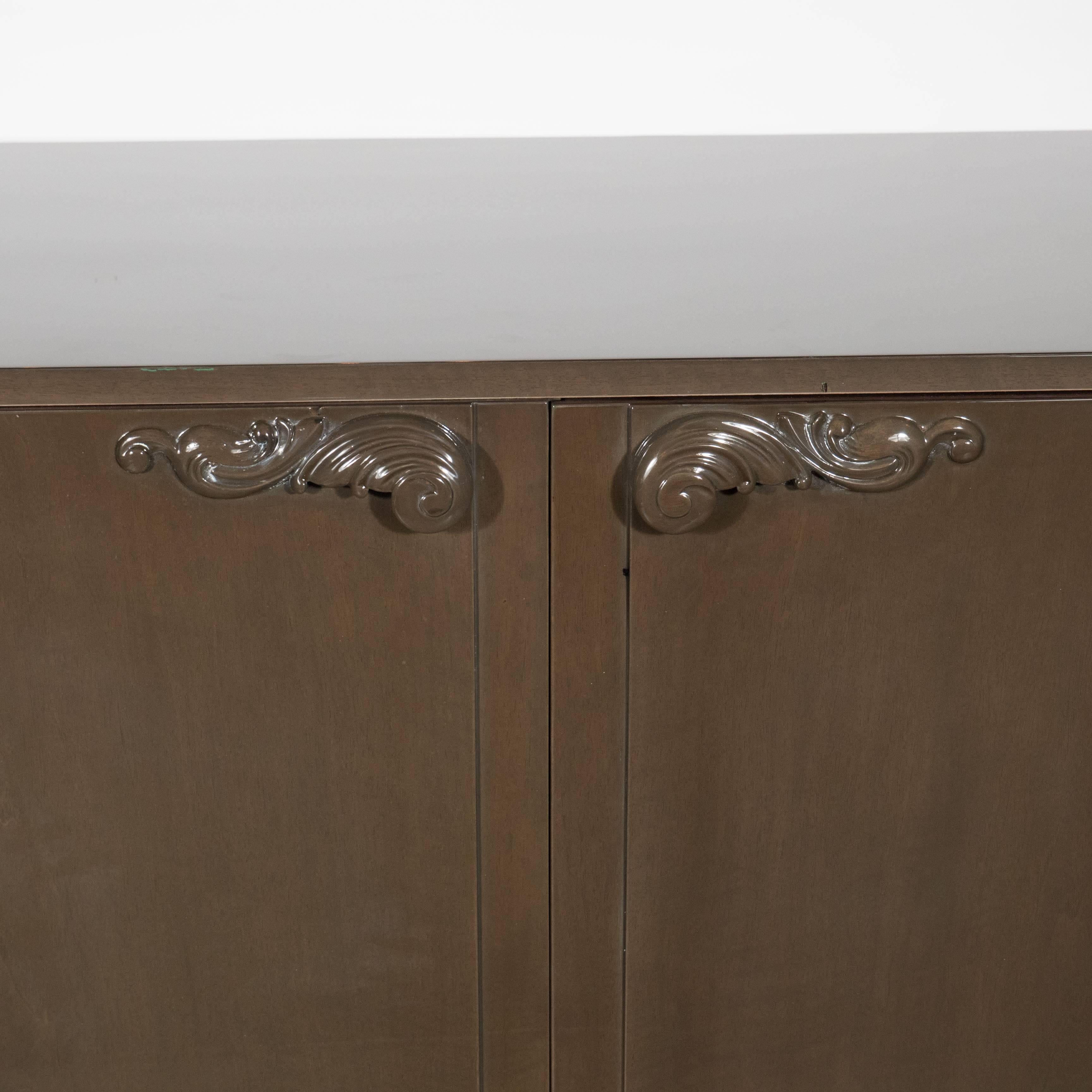 1940s Hollywood sideboard by Lorin Jackson for Grosfeld House features a grey glazed finish on bleached mahogany with scroll form pulls. A clean design that would work well will all types of decor. The interior is mahogany and features four large