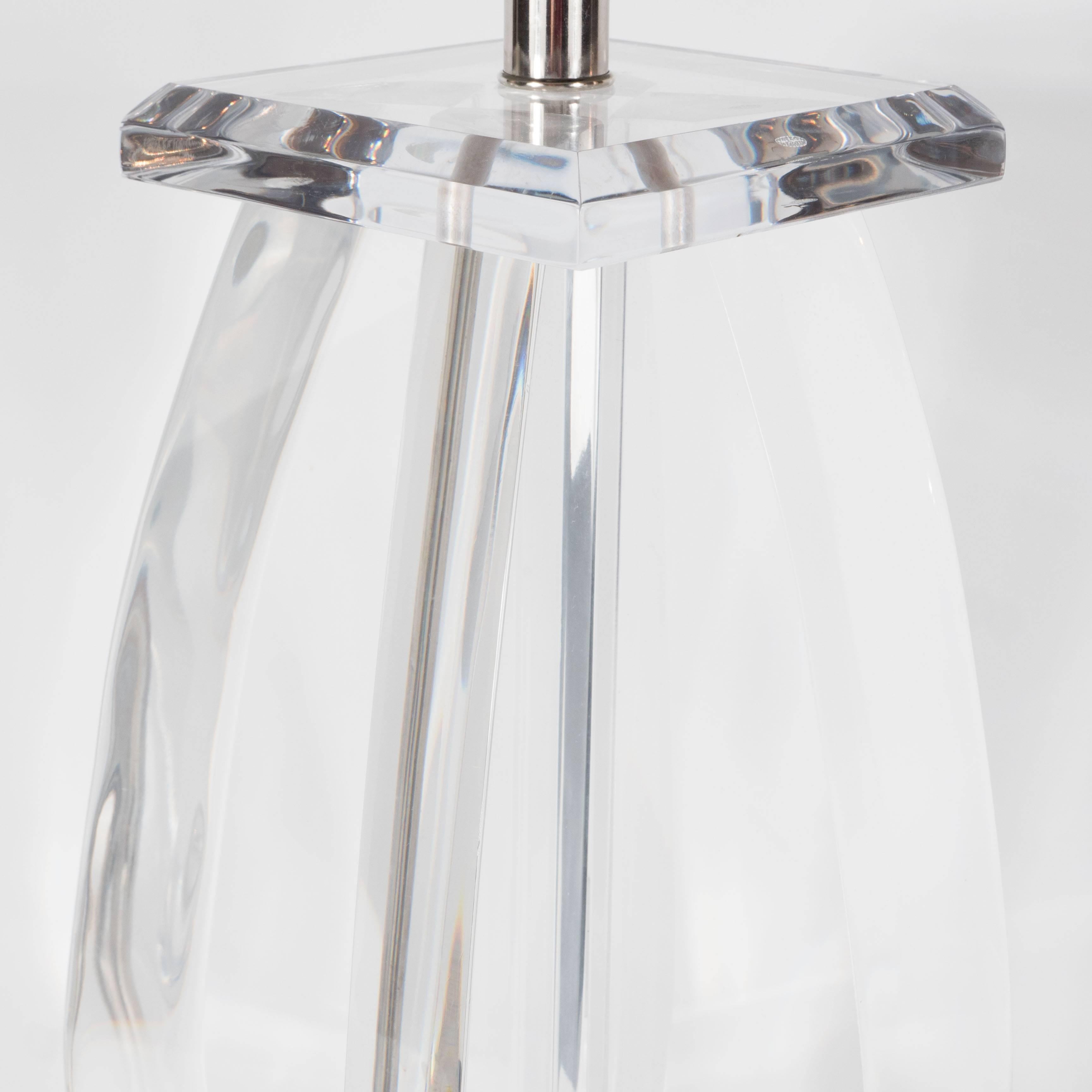 A Mid-Century Modernist Lucite table lamp with chrome fittings. The sculptural design features four teardrop shaped segments in a cross formation between two squares of Lucite forming the base and cap. It is newly rewired and includes a new custom