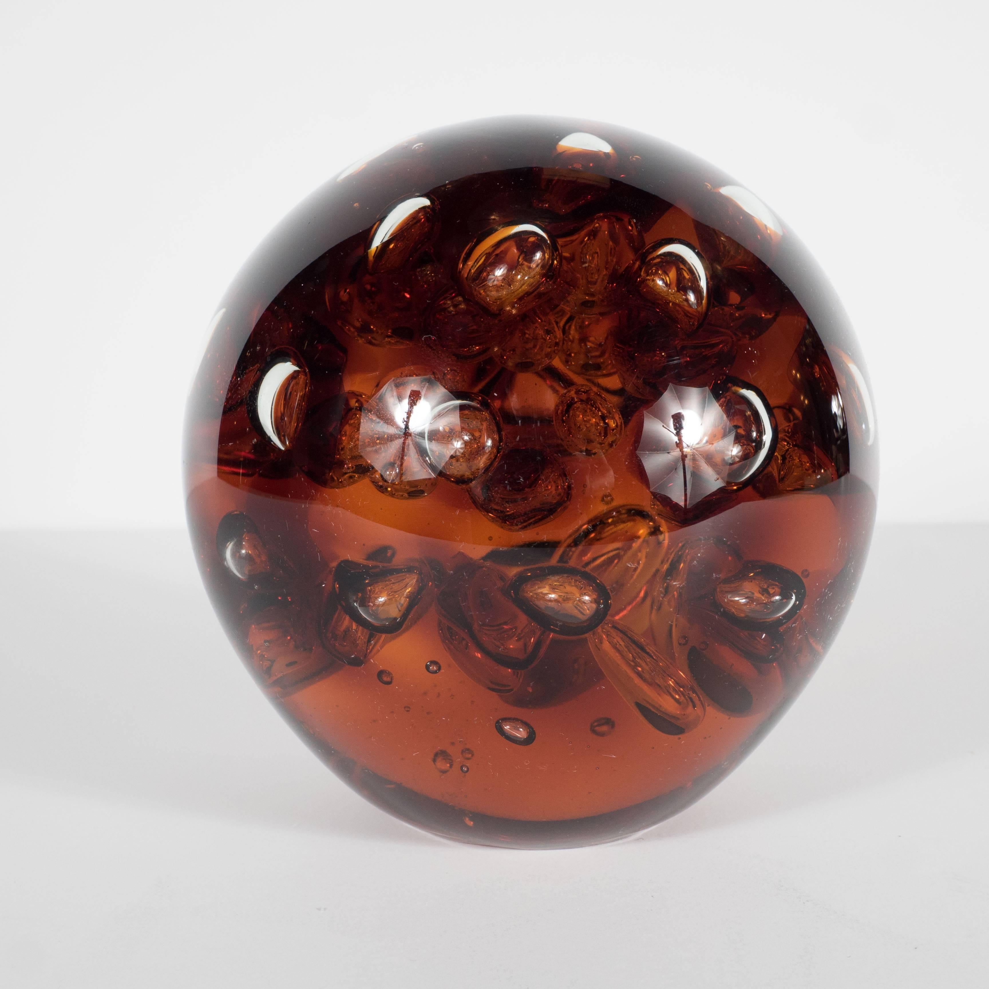 A Mid-Century controlled bubble amber colored glass object. A lovely piece on its own, as a paperweight or part of a set of decorative accessories. Would be wonderful on a book case or cocktail table. It is in excellent condition.