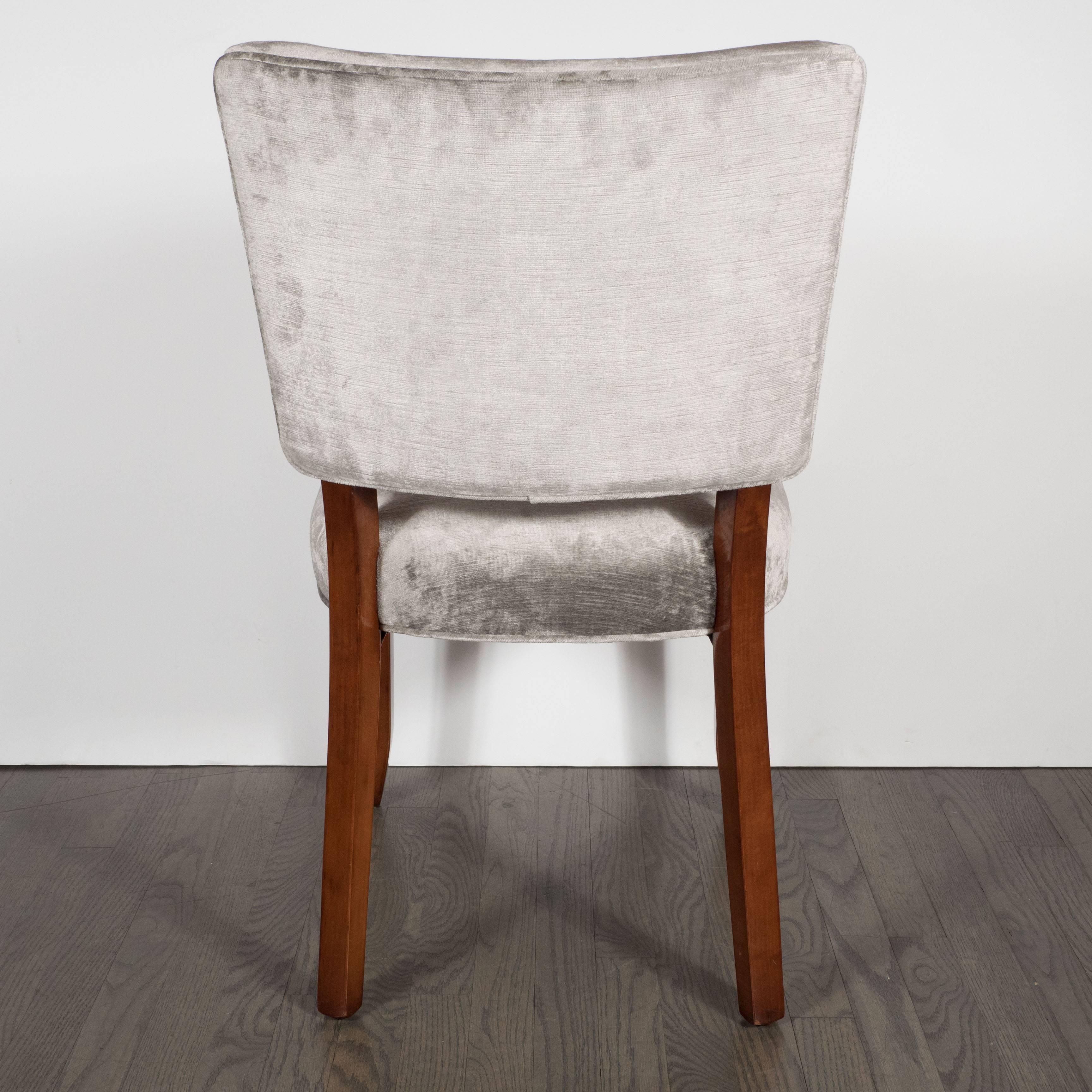 A set of four Art Deco dining chairs, newly upholstered in smoked platinum velvet; the back is contoured for maximum comfort, the frame is walnut with slightly splayed saber legs. They are restored to mint condition.