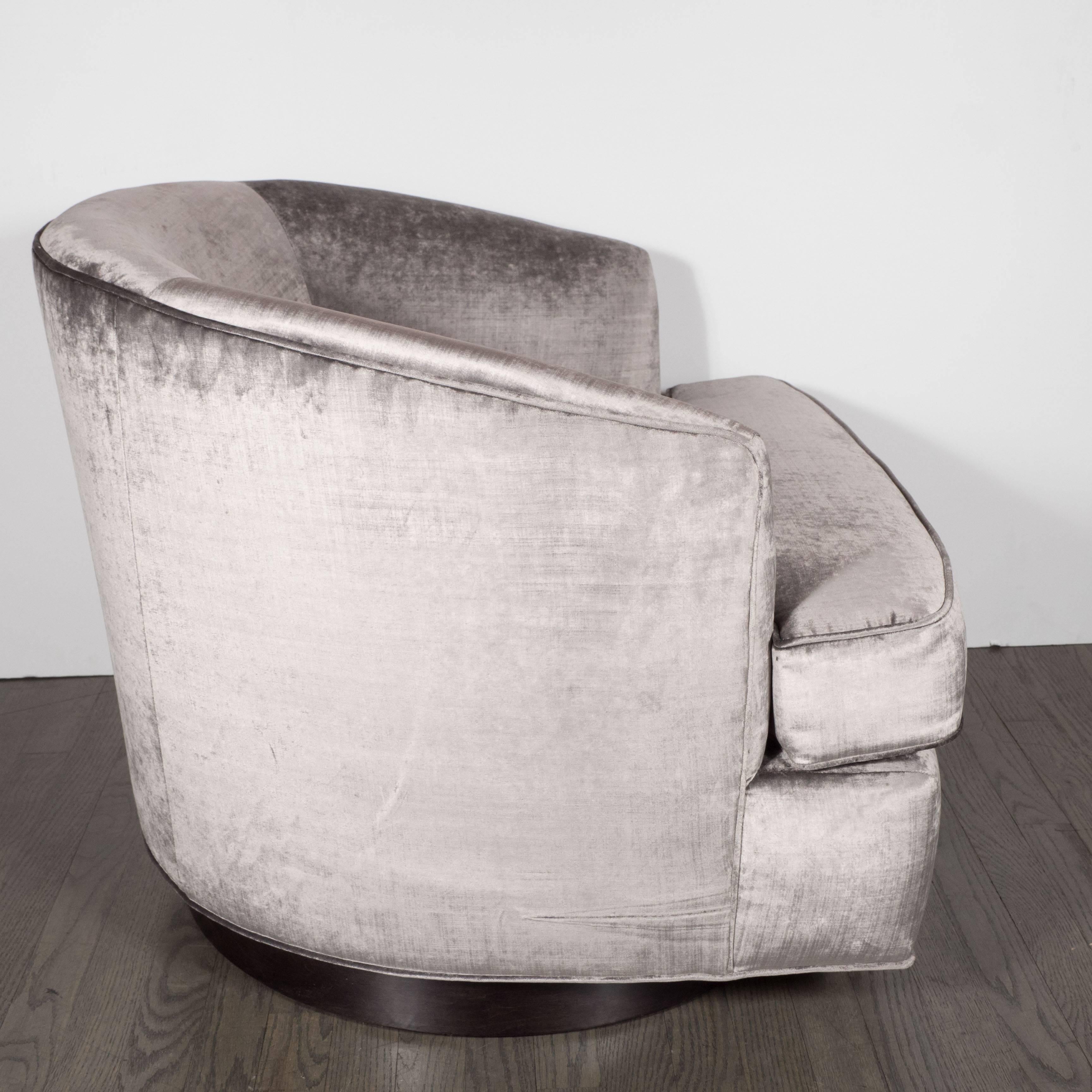 Mid-Century Modernist Milo Baughman swivel chair in platinum grey velvet with ebonized walnut base, American, circa 1970. This chair features a removable, fully upholstered cushion. Narrow arms and minimal detailing lend to a clean, modernist