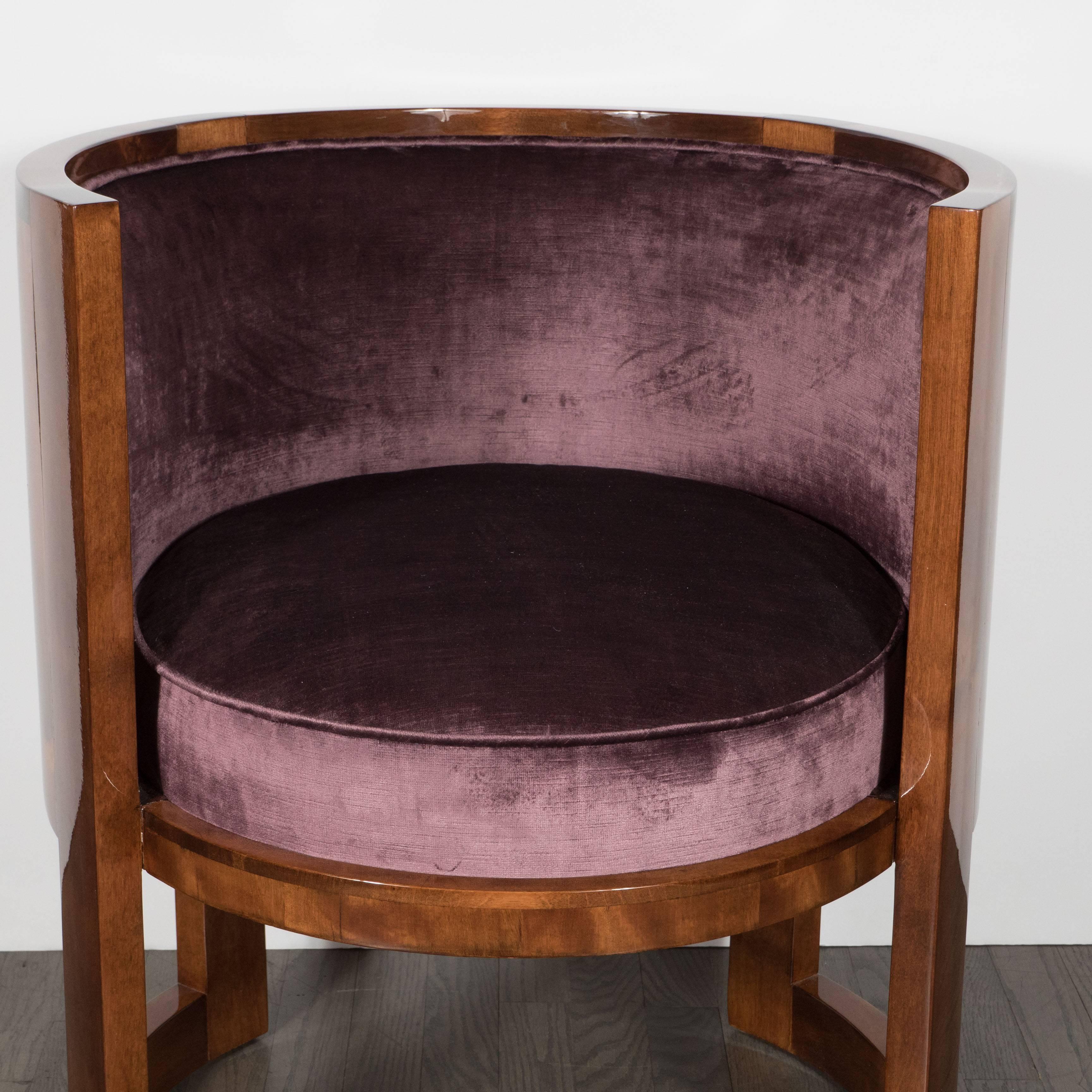 A fine pair of Art Deco curved-back salon chairs in smoked amethyst velvet and book-matched walnut. The elegant wraparound back is partially covered on the back with the dark purple upholstery. All upholstery on seat cushion, back inside and out