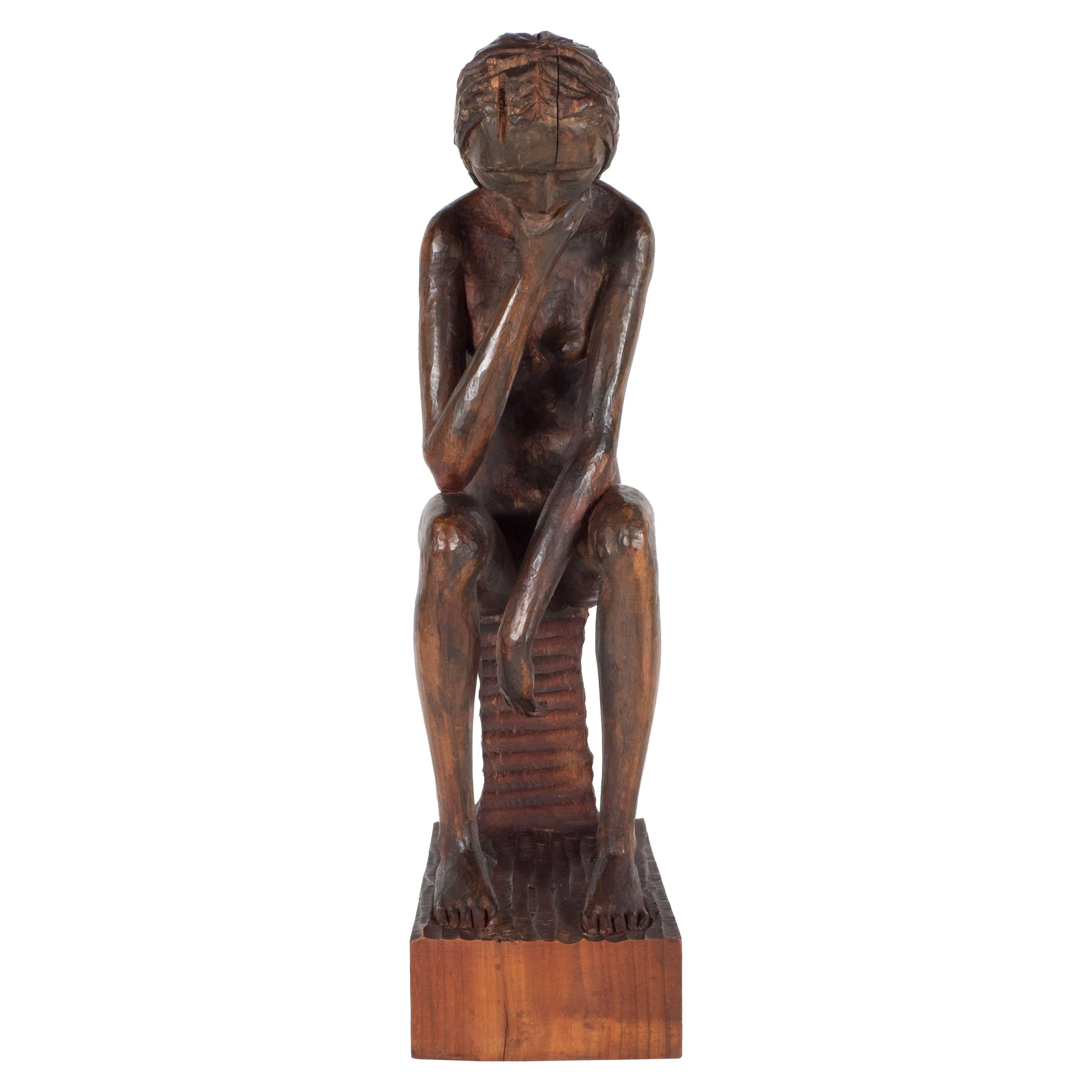 Hand-carved wood sculpture of a seated contemplative woman by an unknown artist.
Seated woman on a rectangular plinth
wood.
Measures: 17