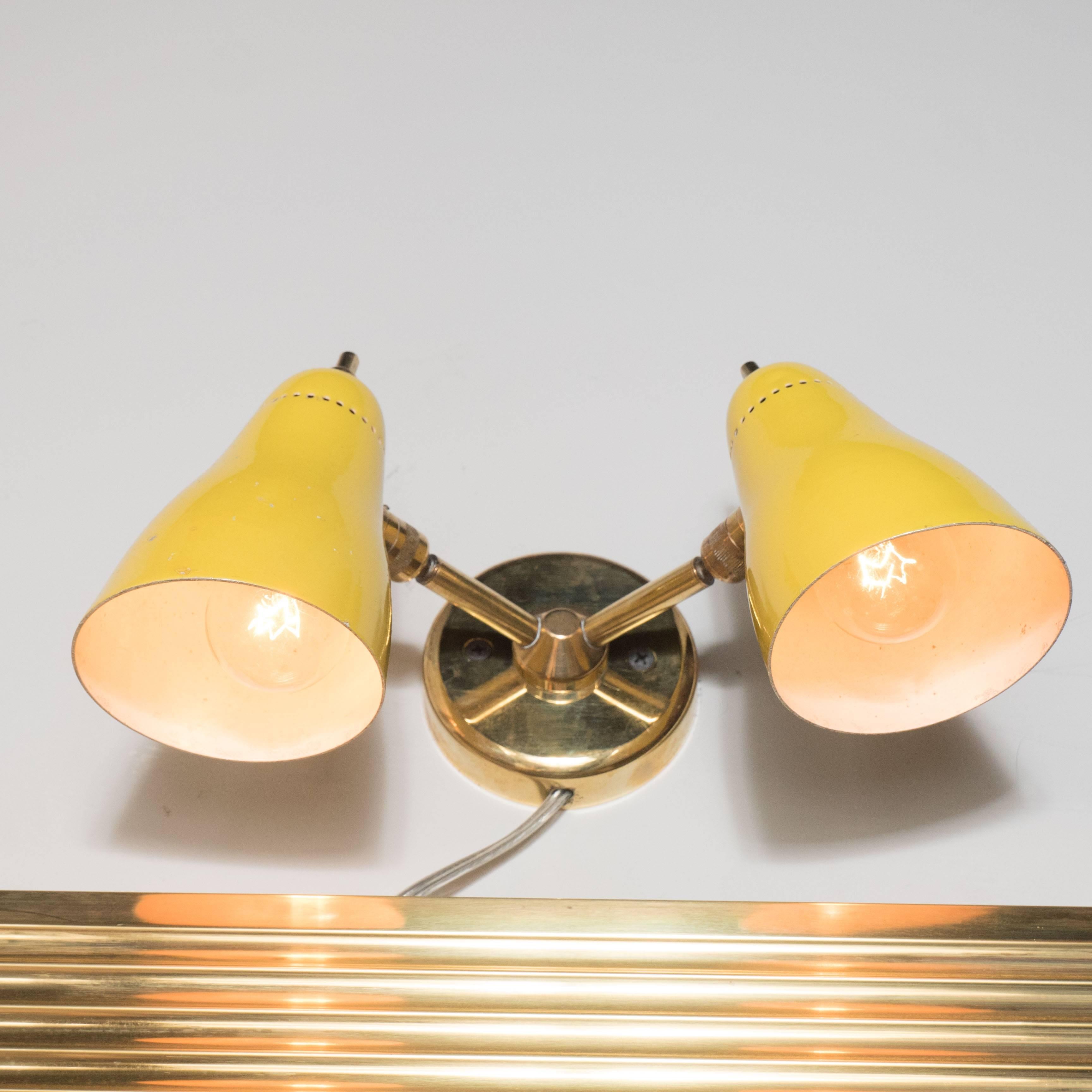 Stylish Mid-Century yellow enamel and brass sconce, Italy, circa 1960. The two conical shades enameled in rich yellow with brass arms leading to a circular brass wall support. A great example of iconic Italian Mid-Century design. 

This item has