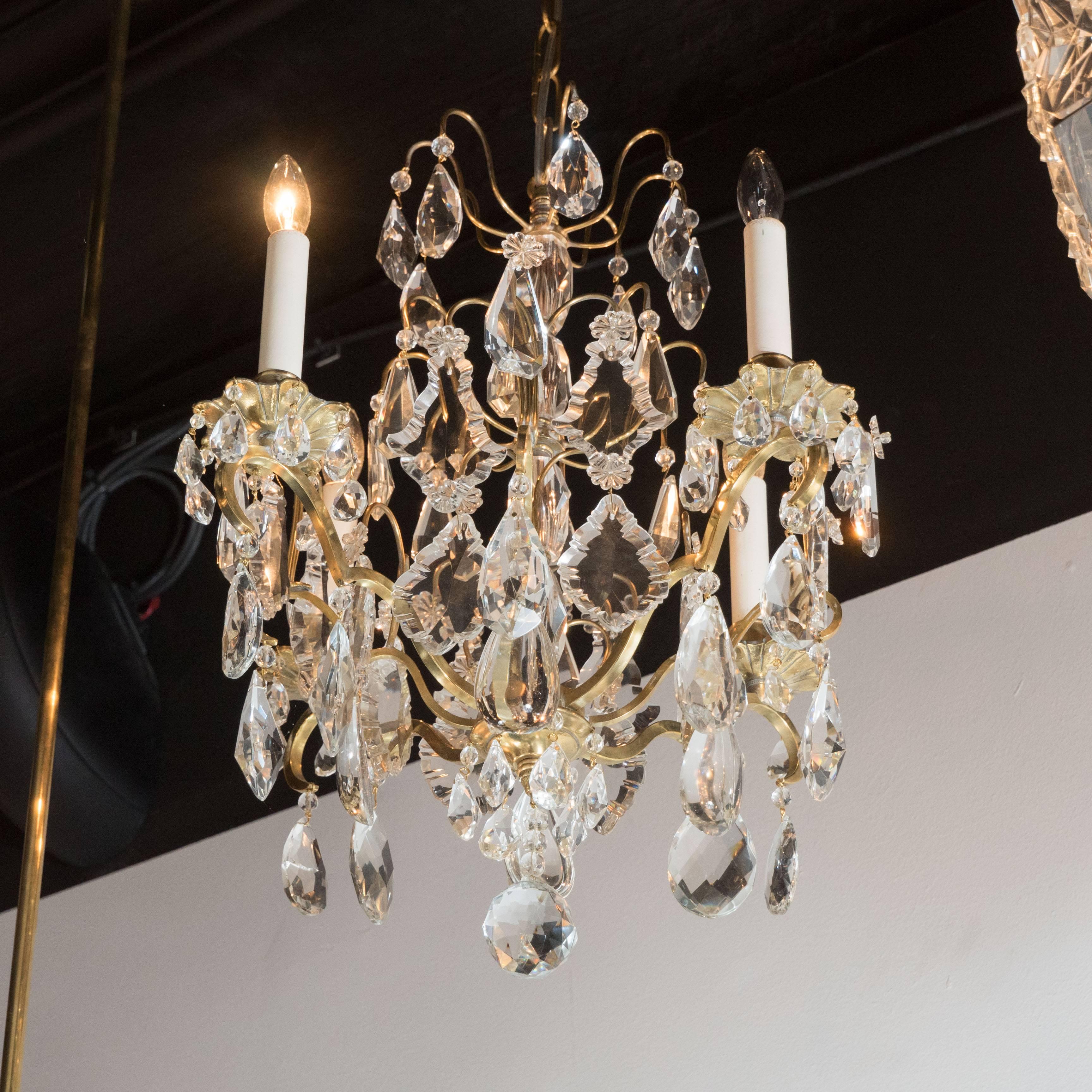 A Louis XV style gilt bronze and rock crystal four-light chandelier of cage form, with central knotted baluster and tier of prisms, with a large faceted round cut crystal ball form pendant. Newly rewired and height can be adjusted to suit.