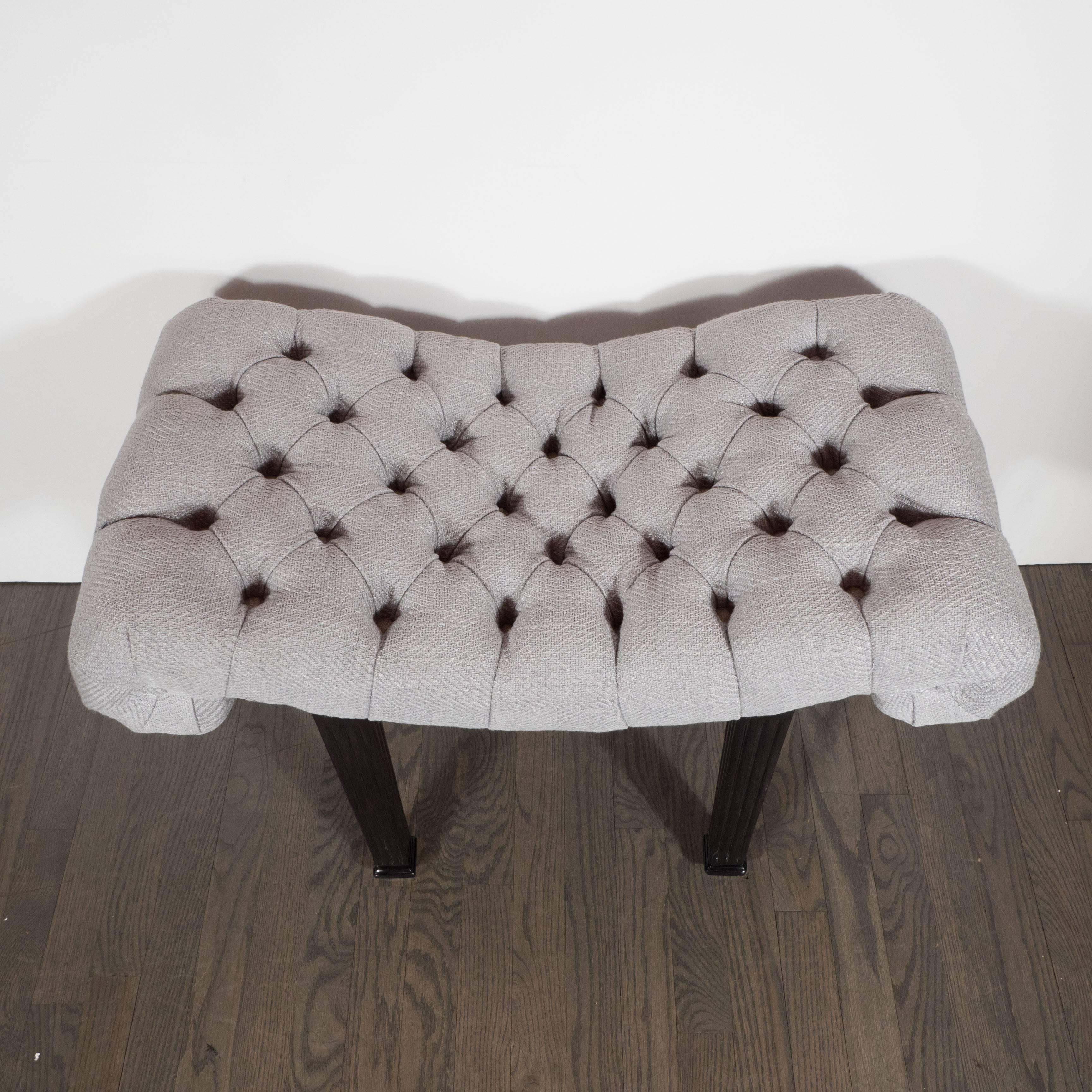 1940s Hollywood Regency scroll design button tufted bench by Grosfeld House in ebonized walnut and silver-blue textured fabric, attractively decorated with button tufts creating a sumptuous soft, curvy and sensual quality typical of the Hollywood