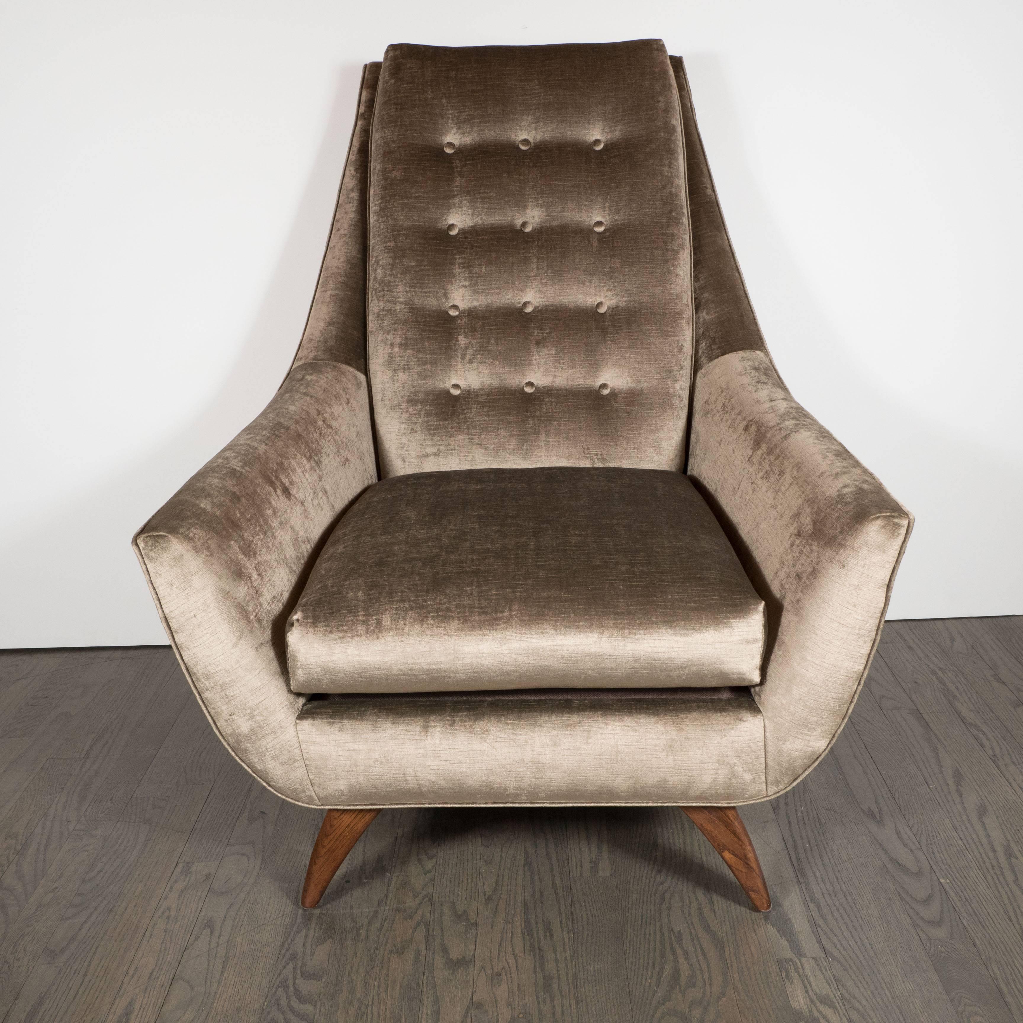 An sophisticated Mid-Century Modernist button back club chair by Adrian Pearsall in walnut and smoked platinum velvet, American, circa 1960.
This stylish club chair on attractively splayed tapered walnut legs; the seat itself sports a large