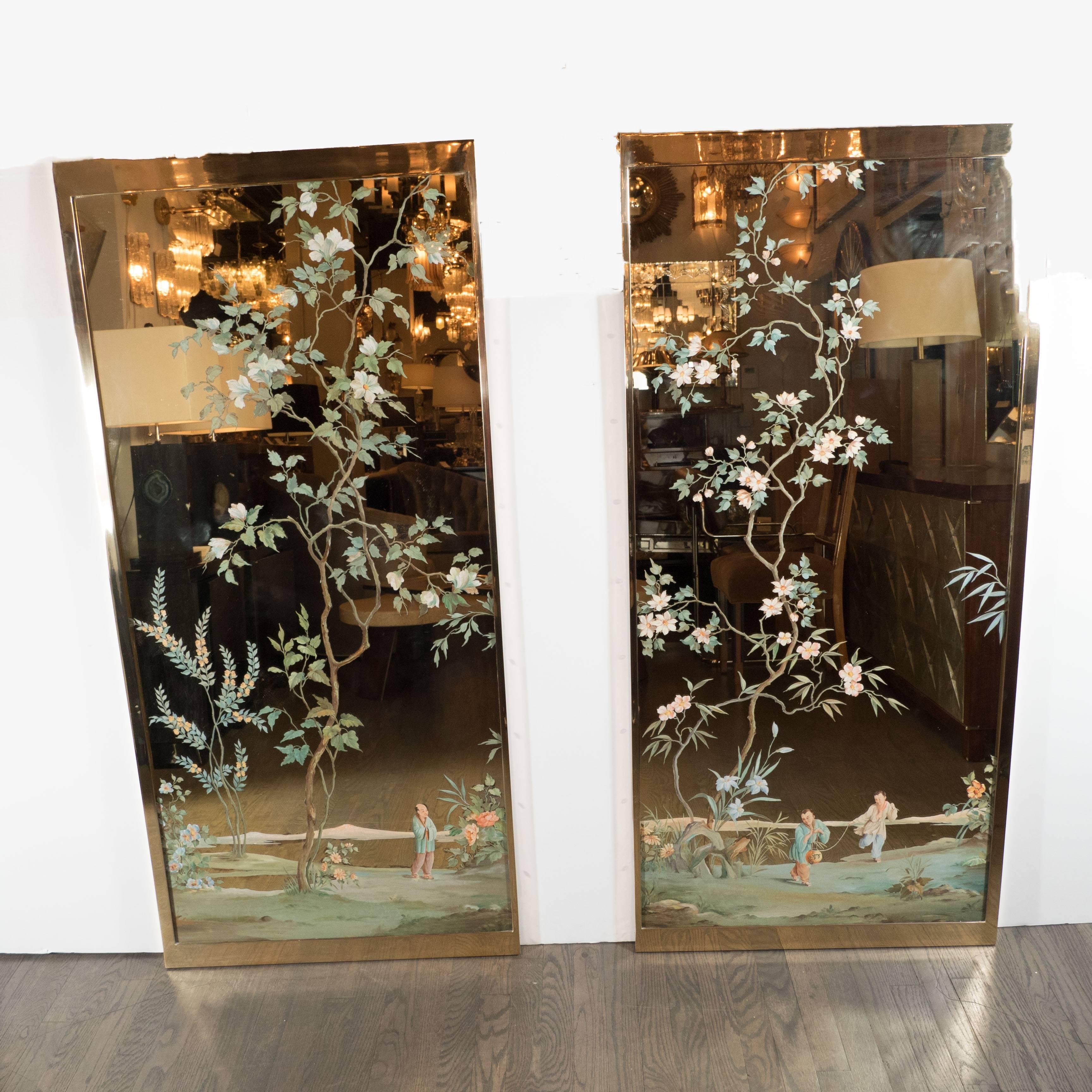 A pair of Mid-Century Modernist mirrors with reverse painted chinoiserie garden scenes, one panel depicts a young couple frolicking about a landscape with various trees, and extensive foliate detailing. The second panel which connects the