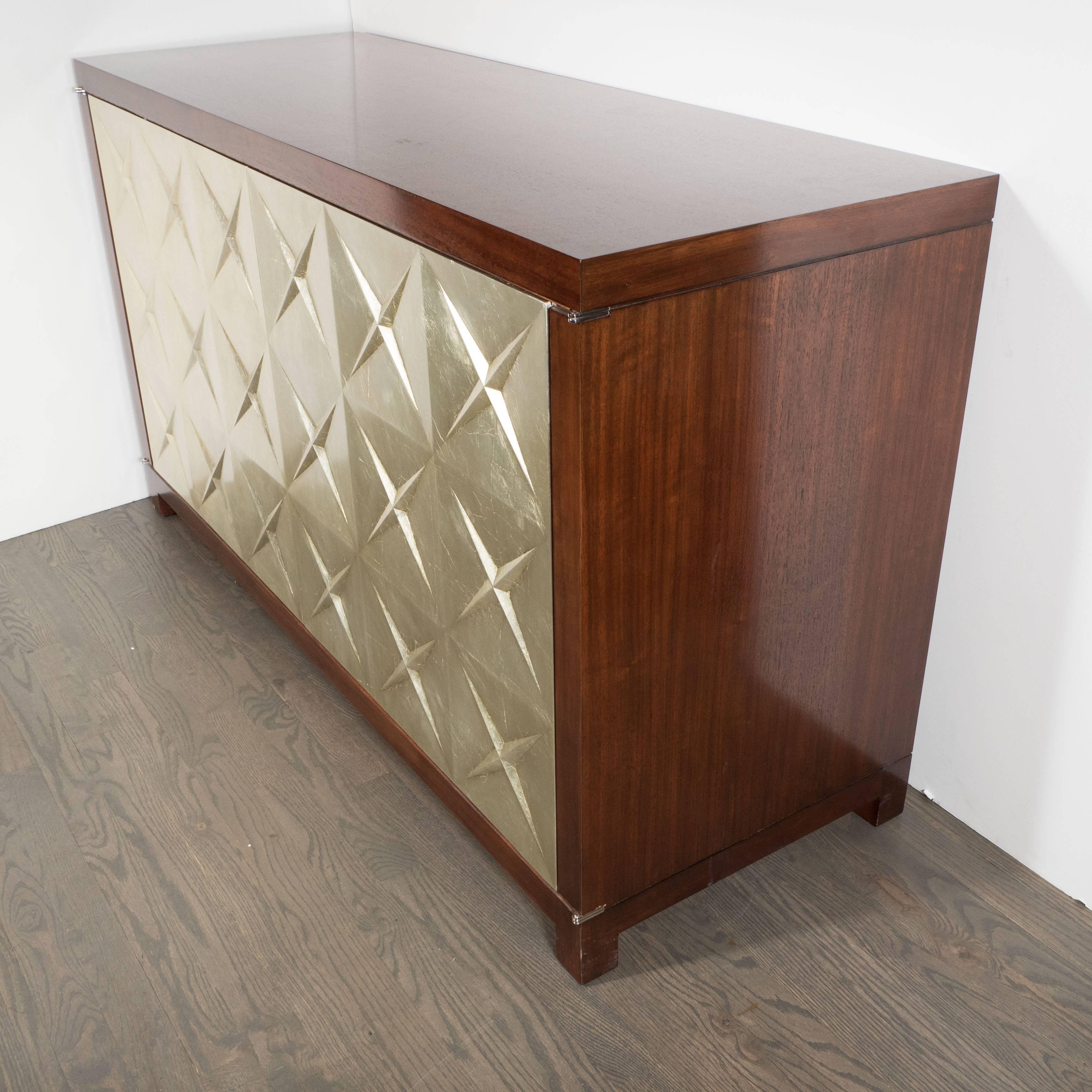 An elegant custom Modernist silver leaf and mahogany cabinet, the front, comprised of two generous doors is attractively decorated with star shape designs in rich silver leaf, the Mahogany with well defined grain, the inside is separated into two