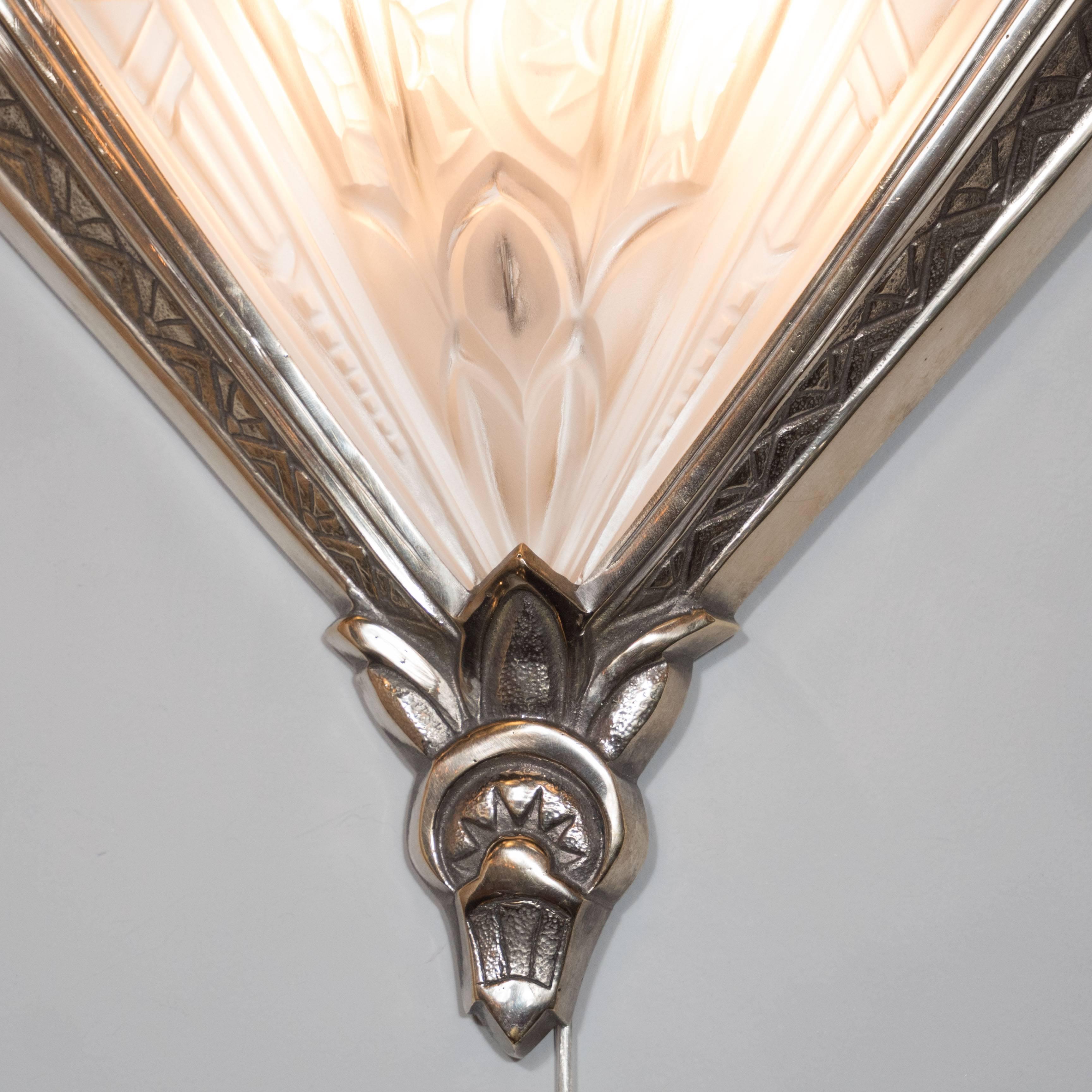 Set of four French Art Deco motif sconces in frosted glass, signed Frontisi. Nickeled bronze V-bases with etched geometric patterns support fan-like frosted glass shades featuring extensive foliate and floral detailing. Each sconce is fitted with