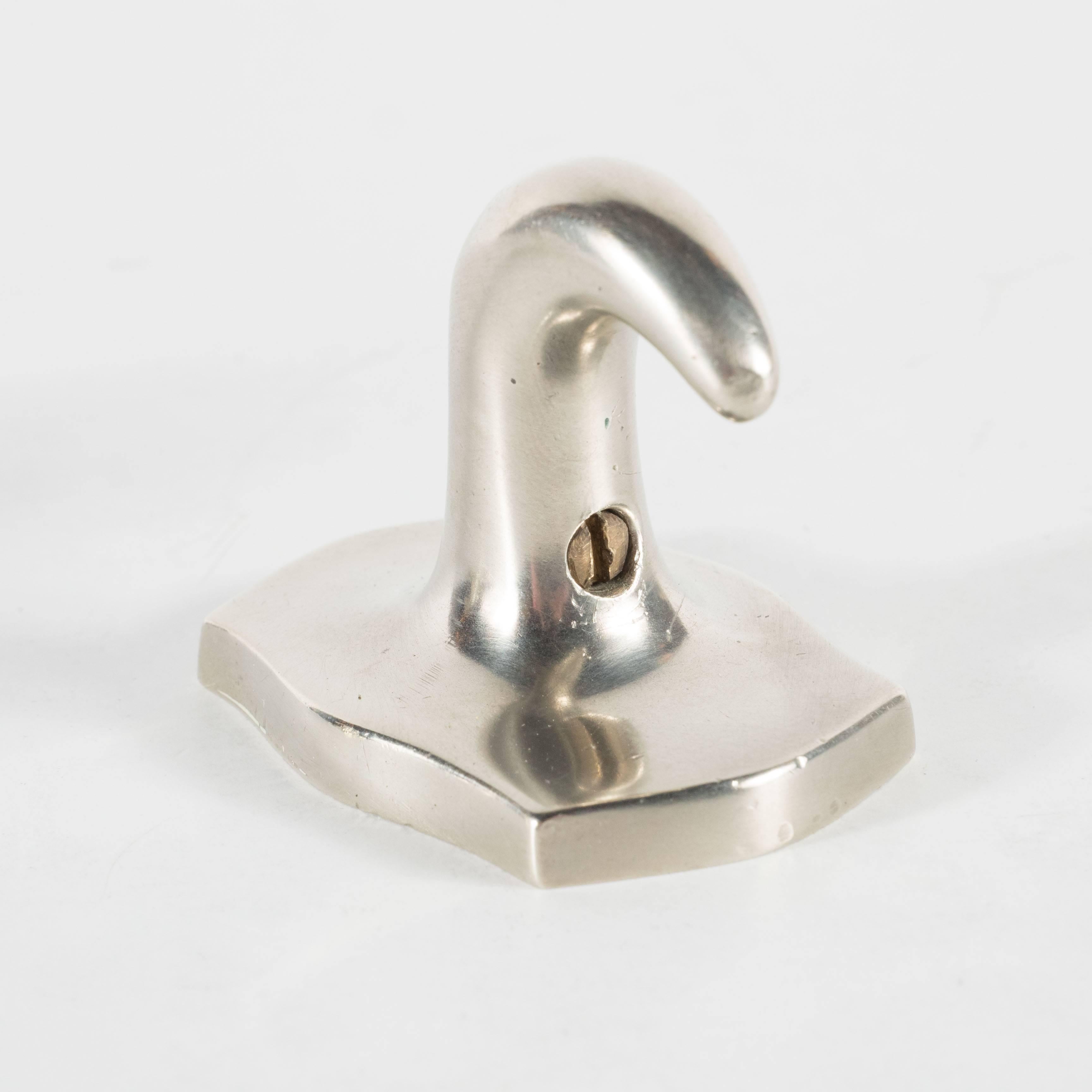 Mid-Century Modernist pair of elegant towel hooks in brushed nickel with interesting shaped stylized wall mounts bases all in highly finished nickel, the simple yet elegant design is highly reminiscent of the Art Deco period, in excellent