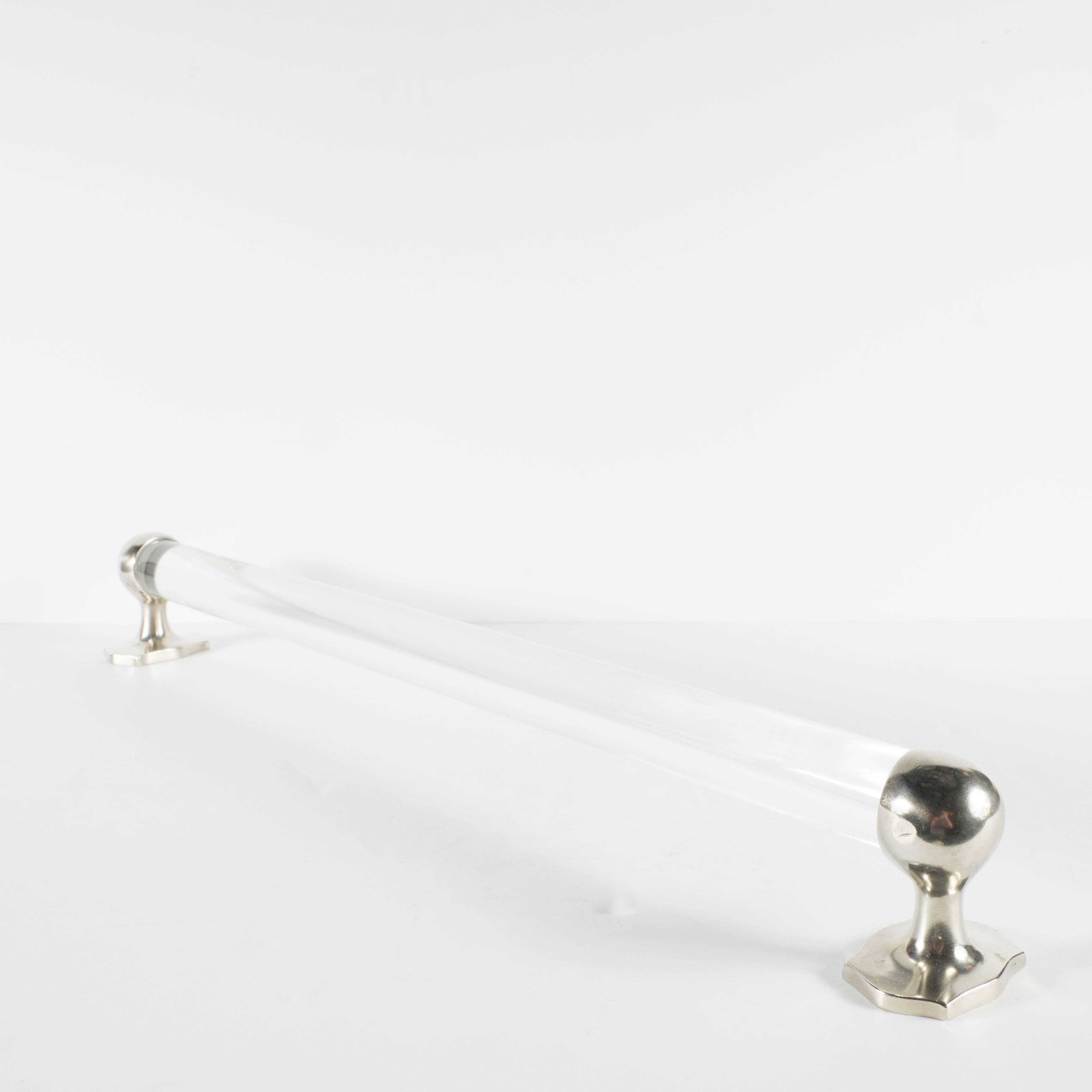 A stylish Mid-Century Modernist Lucite and brushed nickel towel rod attractively finished in transparent circular shaped Lucite with bold round nickel end fixtures somewhat reminiscent of the clean Art Deco style. A simple yet stylish design worthy