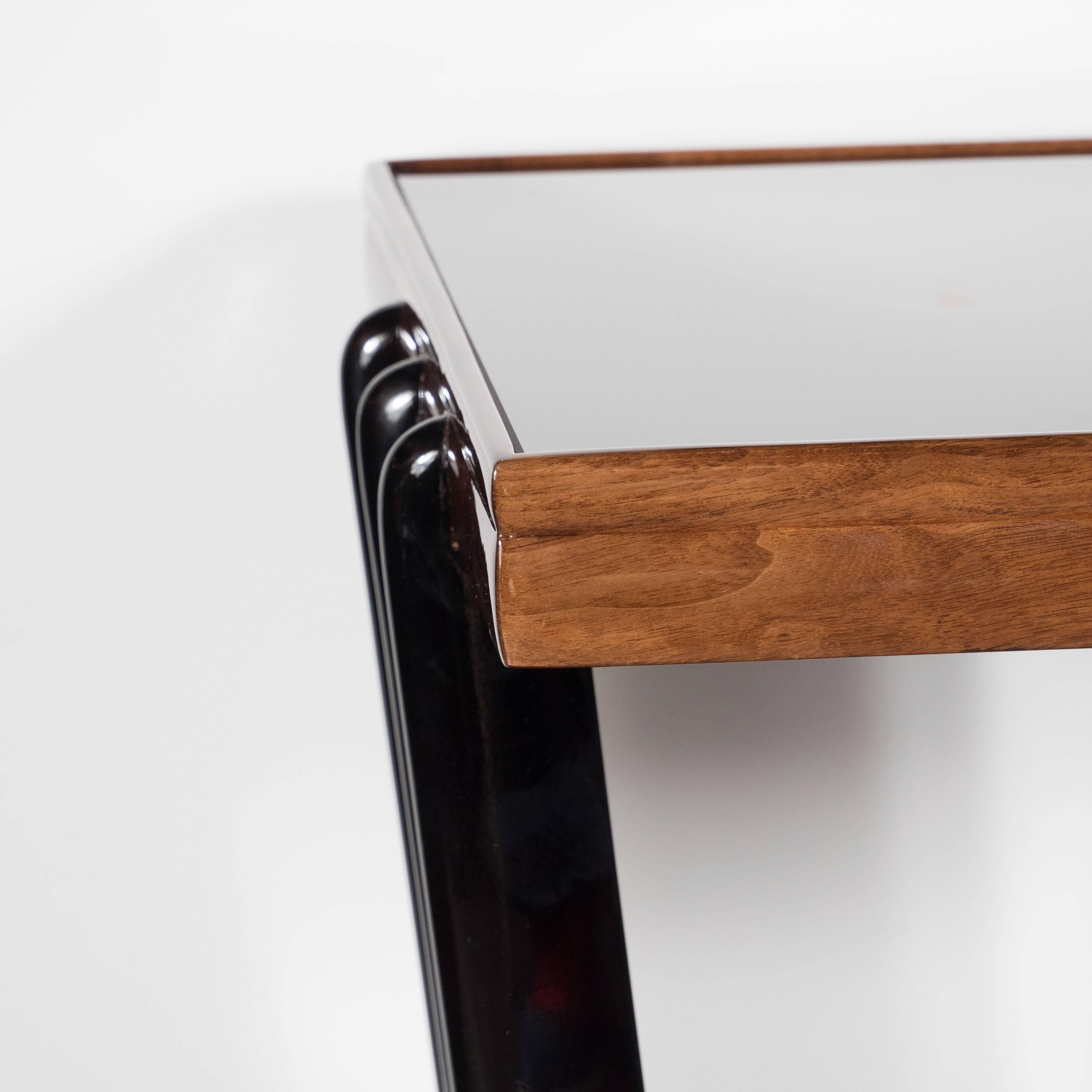A stunning Art Deco Skyscraper end table in bookmatched walnut, black lacquer and vitrolite, American circa 1935, the stylish vitrolite tabletop framed with beautiful grained bookmatched walnut, the table top surround in Modernist streamlined
