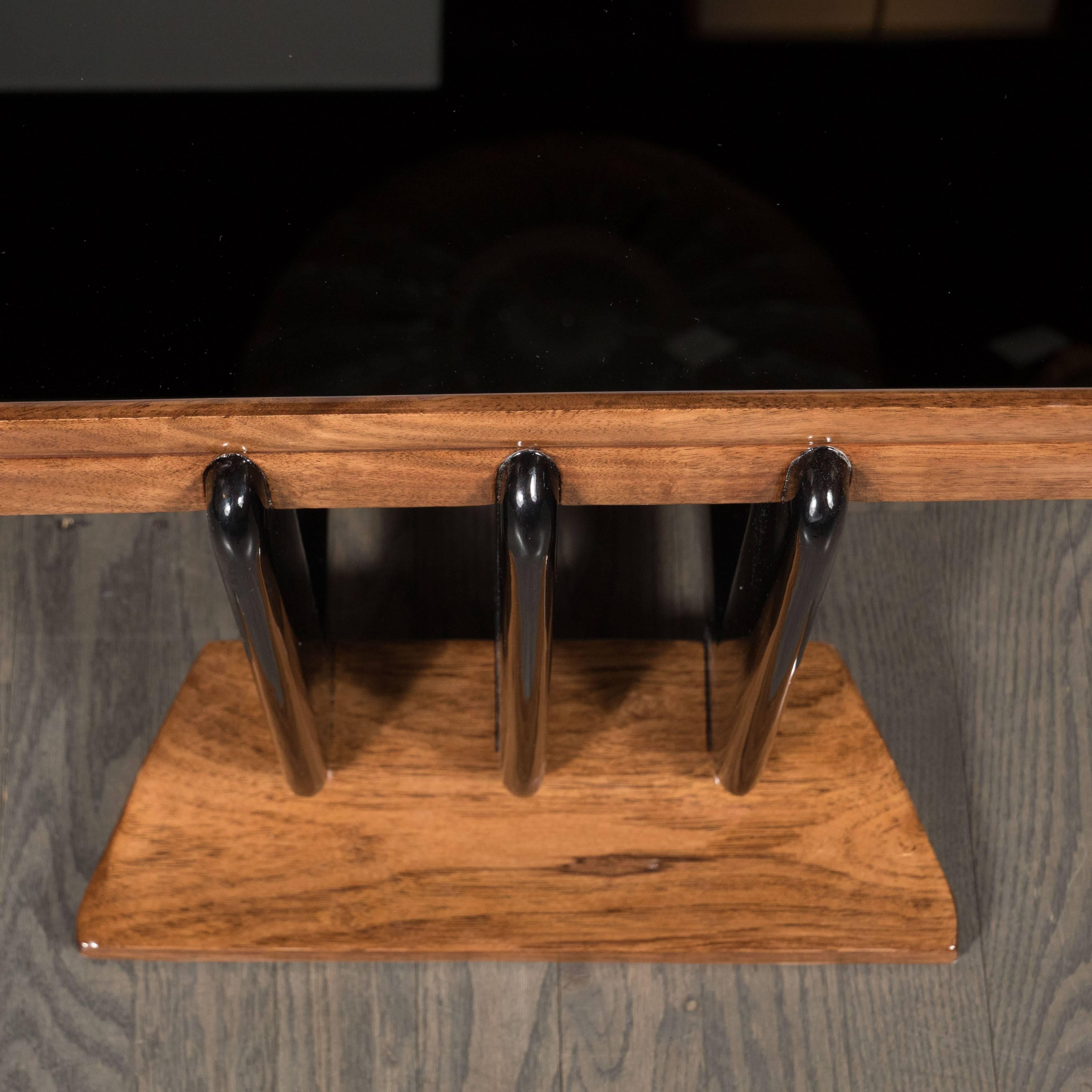 A streamlined Art Deco Skyscraper console table in bookmatched walnut, black lacquer and Vitrolite, the stunning Vitrolite tabletop framed with book-matched beautifully grained walnut, mounted on three sublime streamlined linear black lacquer flat