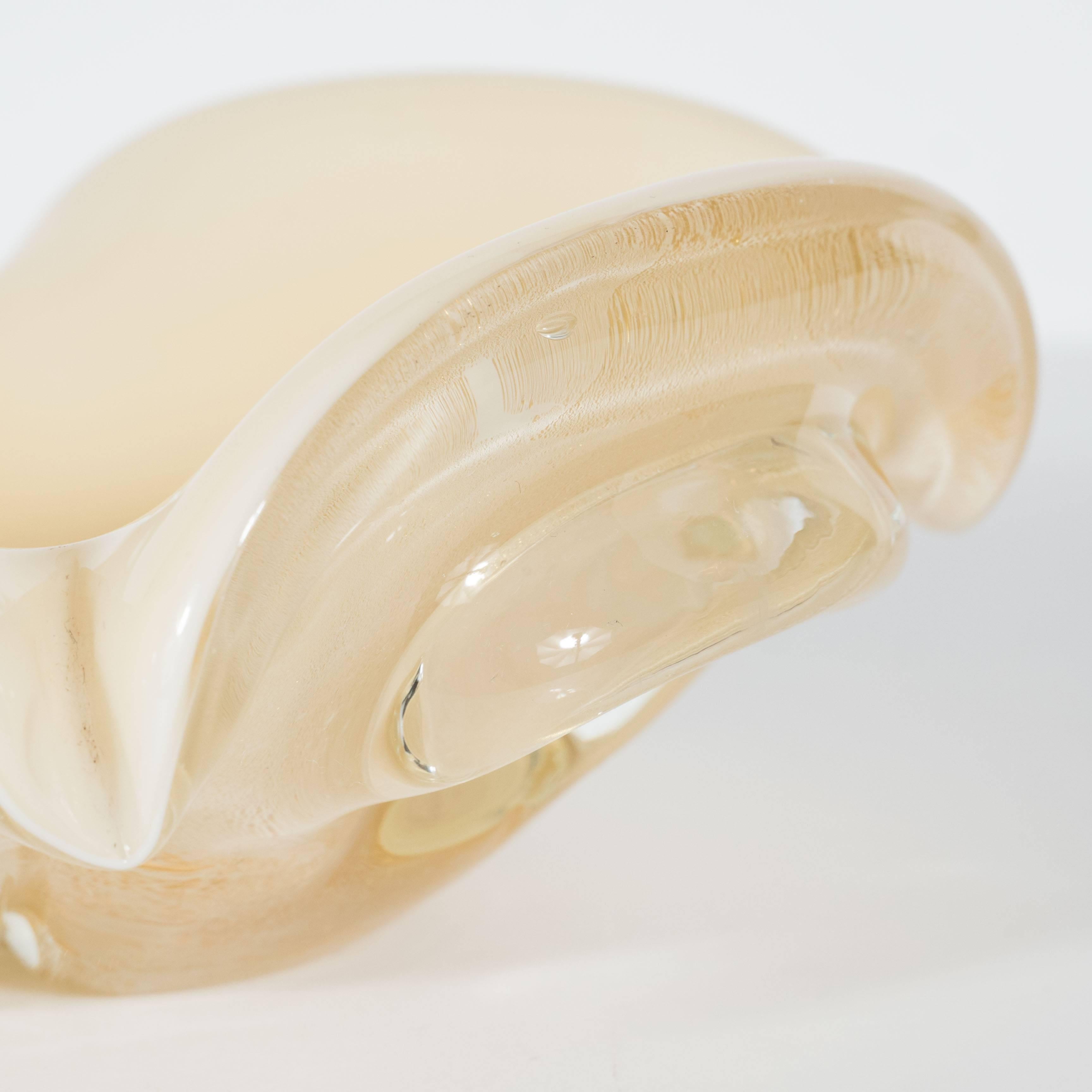 A Mid-Century modernist handblown Murano ashtray or bowl in opaque creme and clear champagne glass with imbedded 24-carat gold flecks. Wide scalloped detailing across the four sides creates four cigarette supports. Although probably designed as an