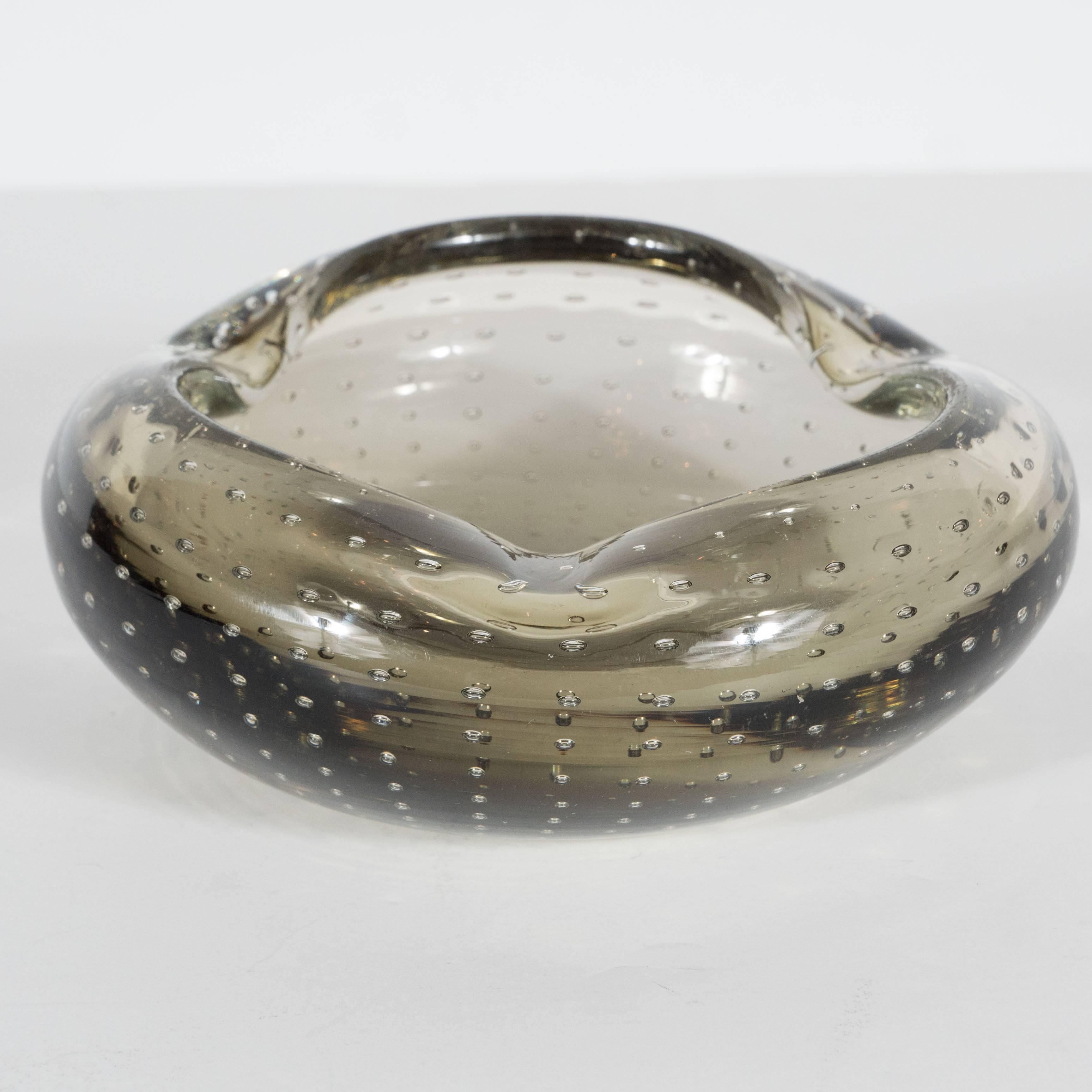 Ultra chic Mid-Century Modern smoked grey Murano glass bowl/ashtray, Italy, circa 1950, the hand blown Murano glass with air bubble inclusion pattern attractively shaped in an organic form. An elegant vide poches, 
Italy, circa 1950. Excellent