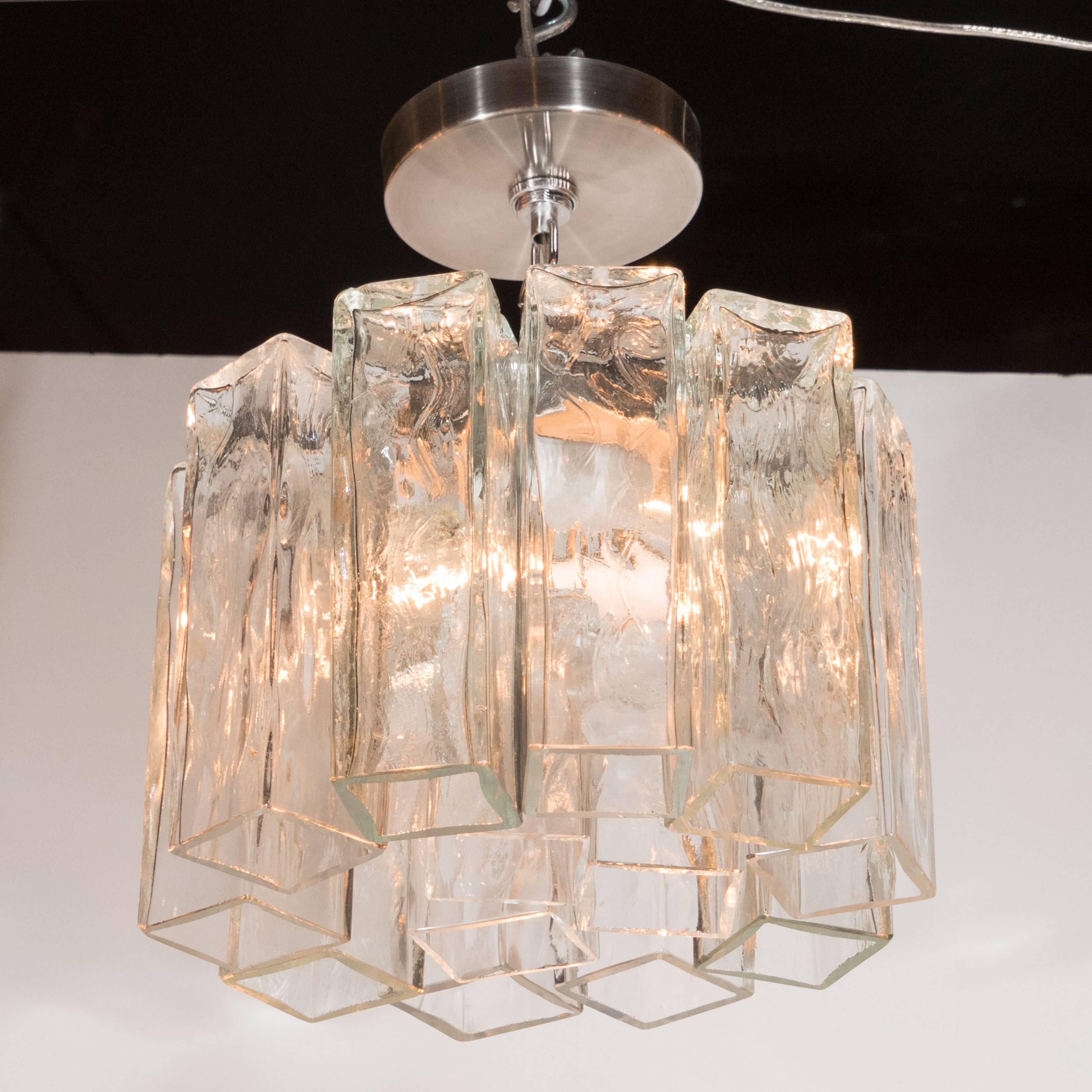 A Mid-Century modernist pendant with textured glass rectangular tronchi hanging prisms. A nickel frame and fittings with two standard candelabra-based sockets, each capable of supporting up to 60W, support thirteen individually hung textured