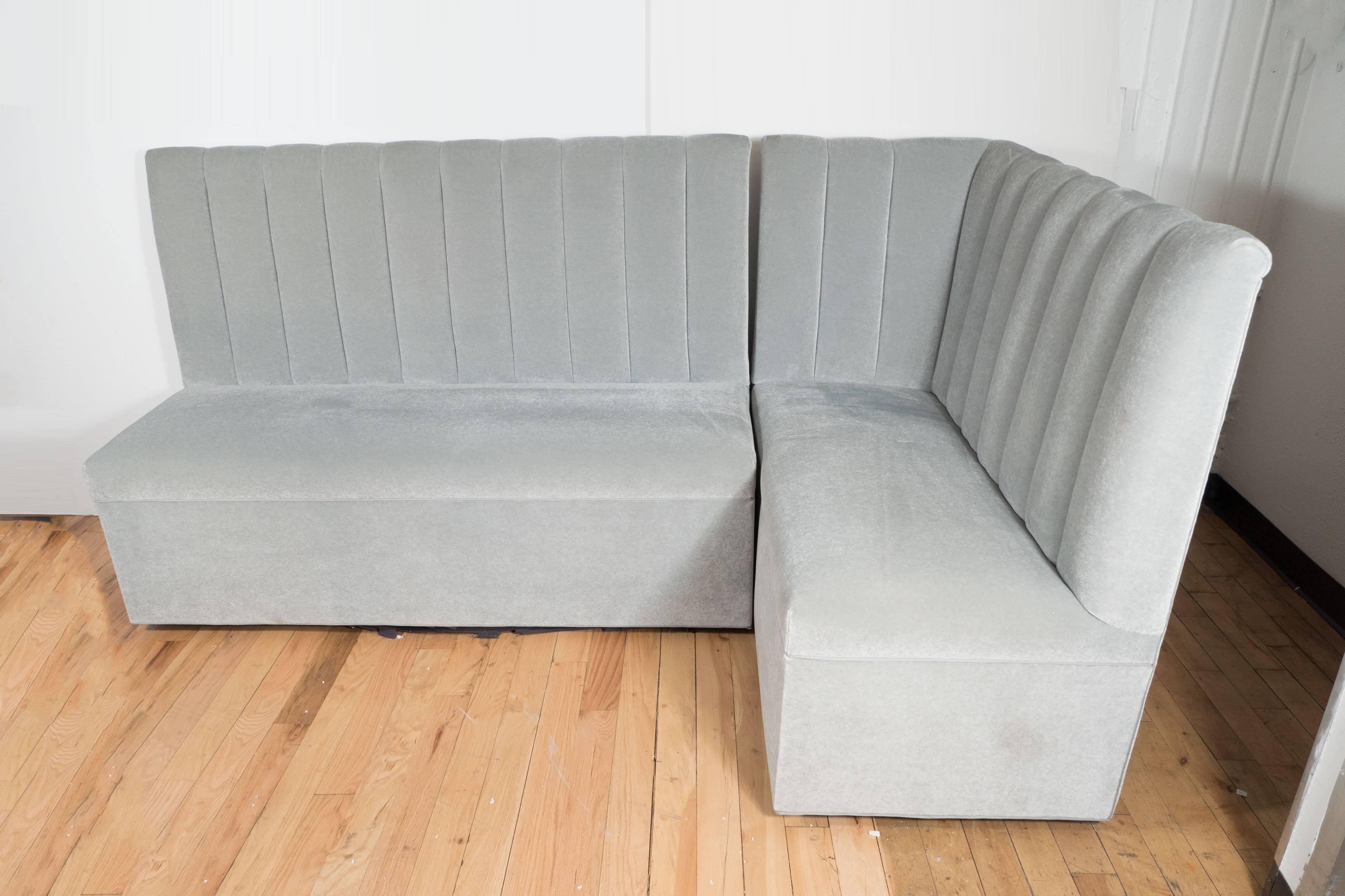 Ultra chic two-part high-back banquette in pearl grey mohair, the back stylishly decorated with vertical quilted slats, the luxurious mohair upholstery elegantly finished with silk piping, the upholstered seat border sitting on almost invisible