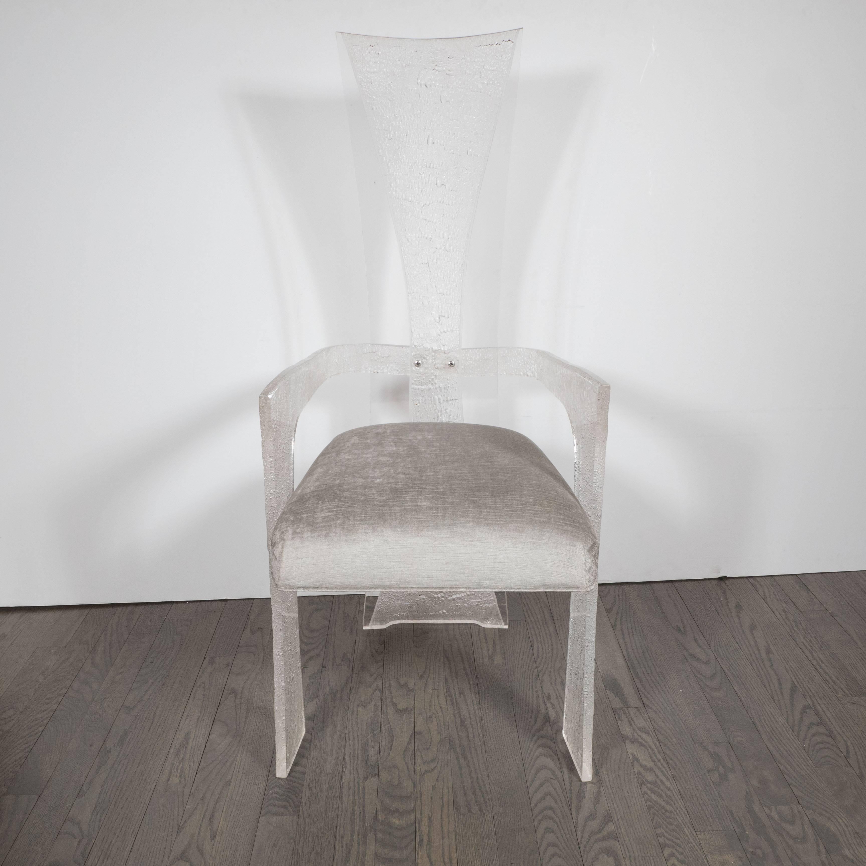 This very sophisticated set of six dining chairs are made of clear and textured or frosted Lucite and feature a sculptural Brutalist design. They have been newly upholstered in a smoked platinum velvet upholstery. They are in excellent