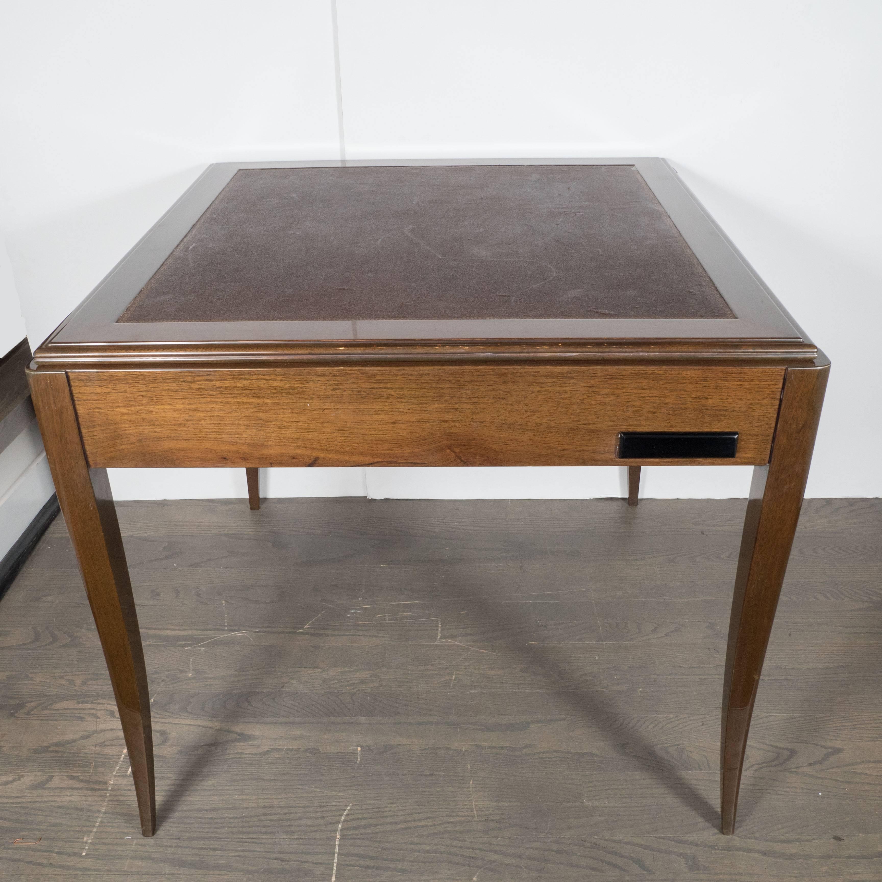 Gorgeous Art Deco game table in book-matched walnut flip-top with original inset leather on one side and also with pull-out black lacquer cup holders. This fine game table features stylized tapered legs. A great example of the Art Deco movement in