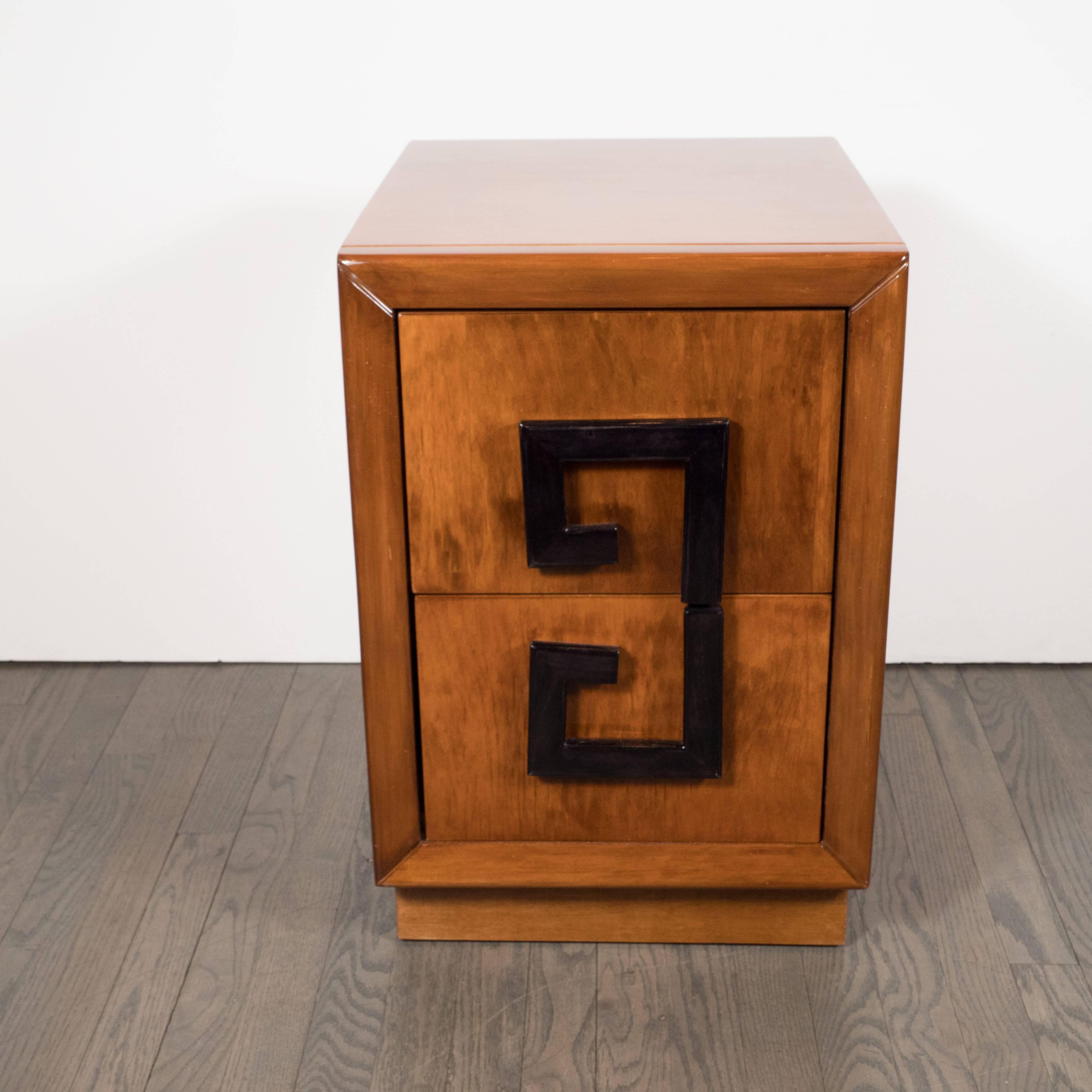 This exquisite pair of elegant Mid-Century Modernist nightstands feature a Greek key design in black lacquer, two spacious drawers and book-matched lacquered walnut. These pieces boast a particularly stunning grain in a lustrous hue of cognac. They