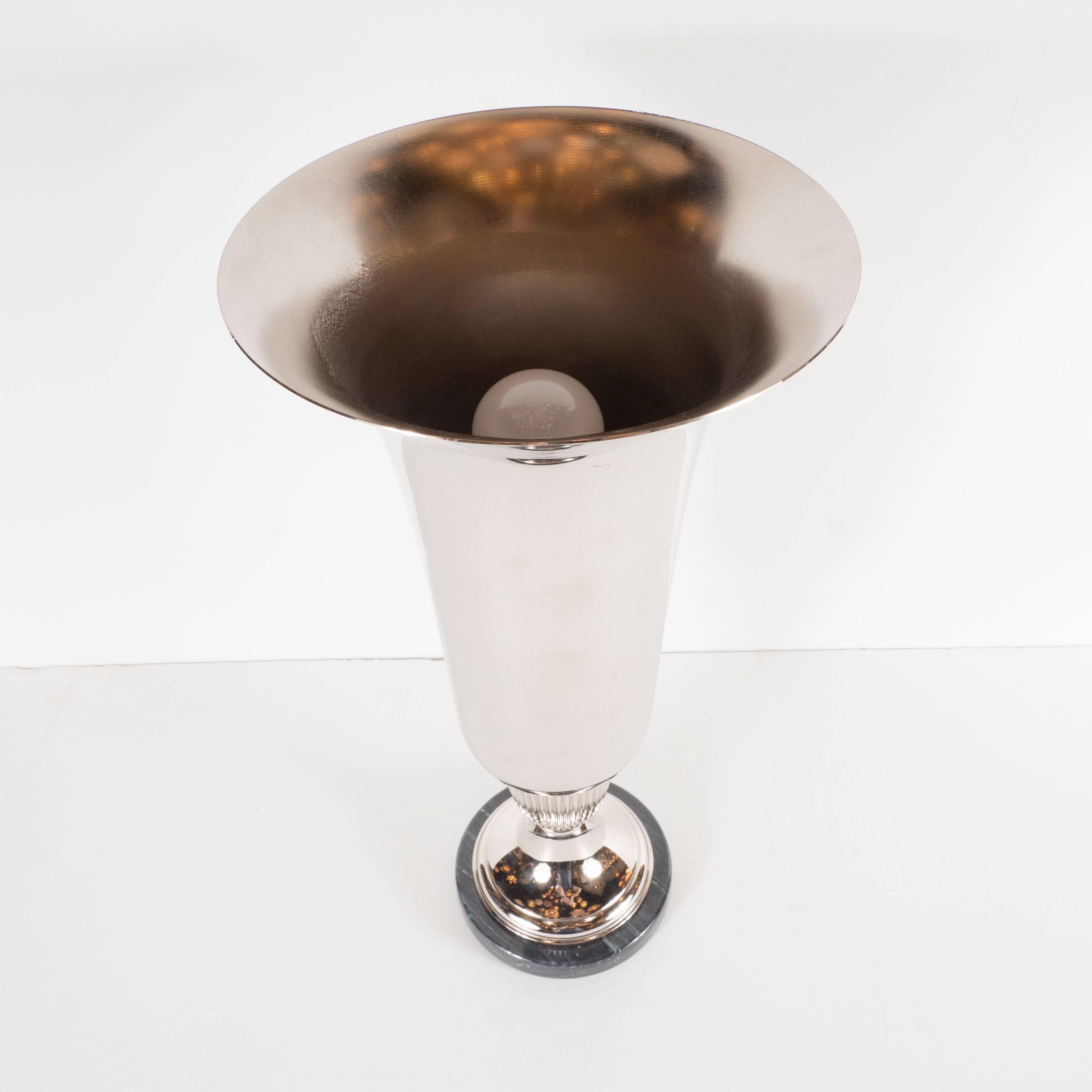 This pair of uplights features lustrous chrome perched atop smoky marble bases. Reminiscent of classical urns, these Art Deco lights have stunning striations- Art Deco flourishes which animate the otherwise austere form. The bell shaped uplights,