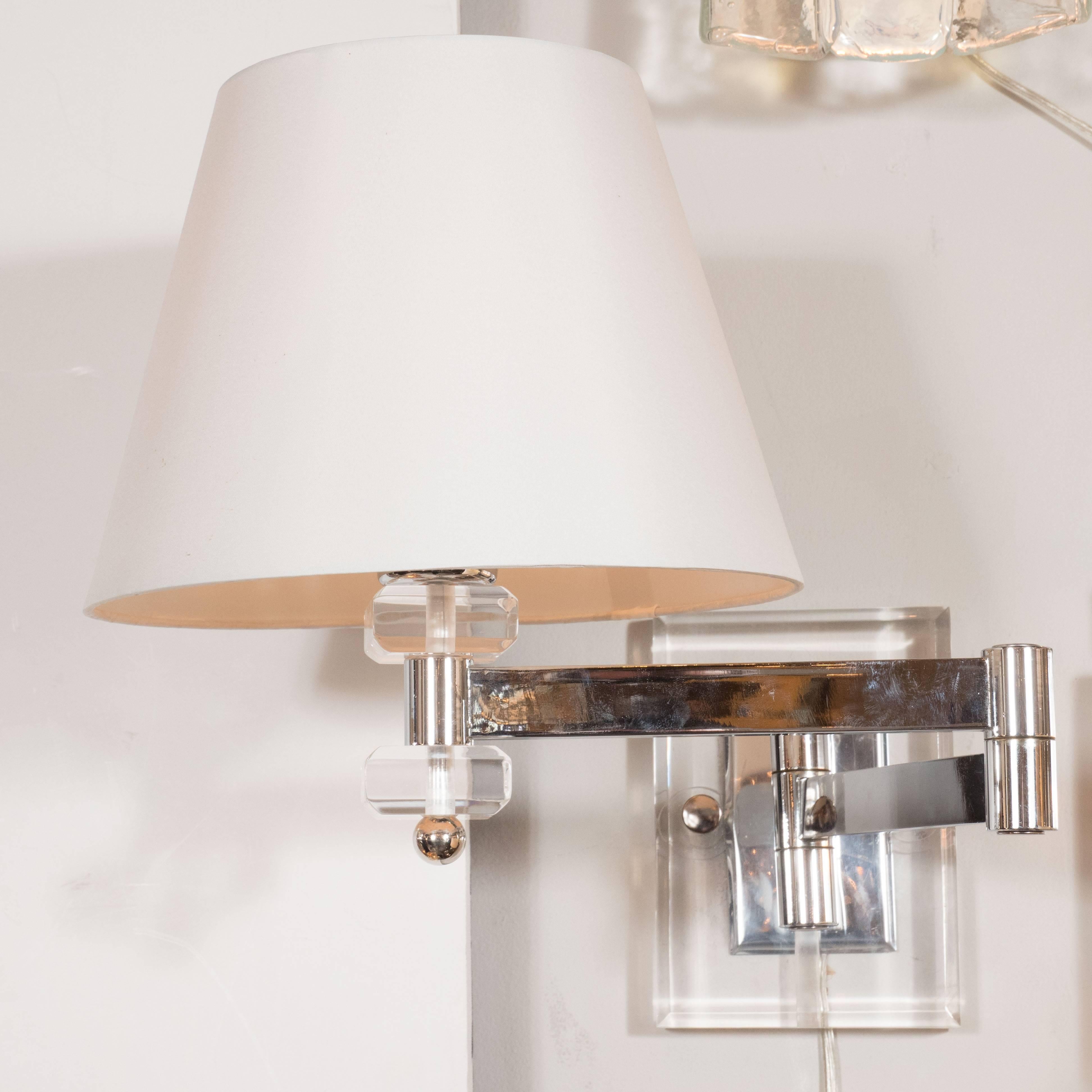 These Mid-Century adjustable swing-arm sconces showcase an economy of design and materials. Fabricated from chrome and Lucite, they are understated and a beautiful addition to rooms of virtually every style and decor. They are newly rewired and