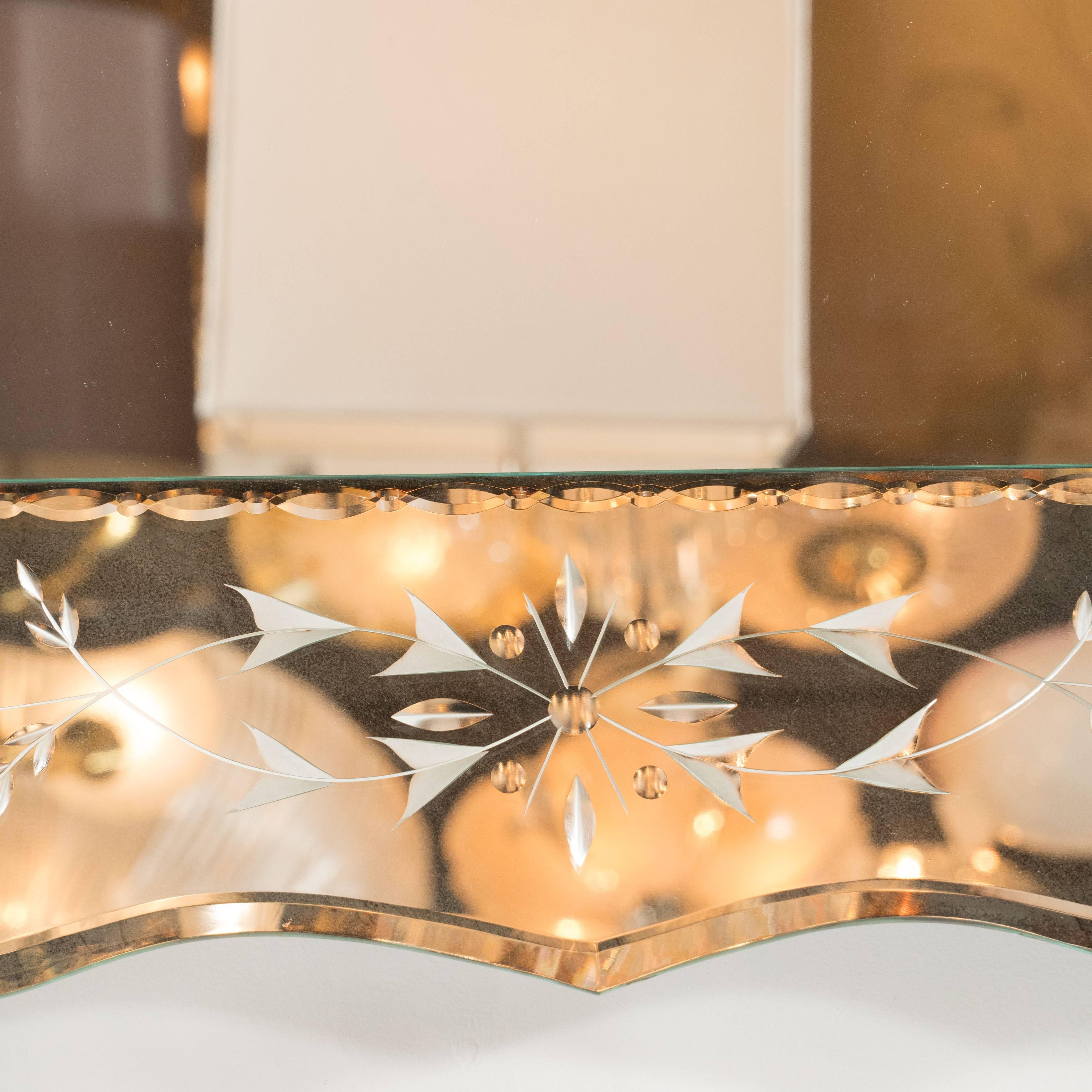 This 1940s Hollywood reverse-etched Venetian-style mirror features beveled scalloped edges on the outer edge with chain beveling inner edge. Geometric and stylized-floral design breathes levity into this substantial vintage mirror. It can be mounted