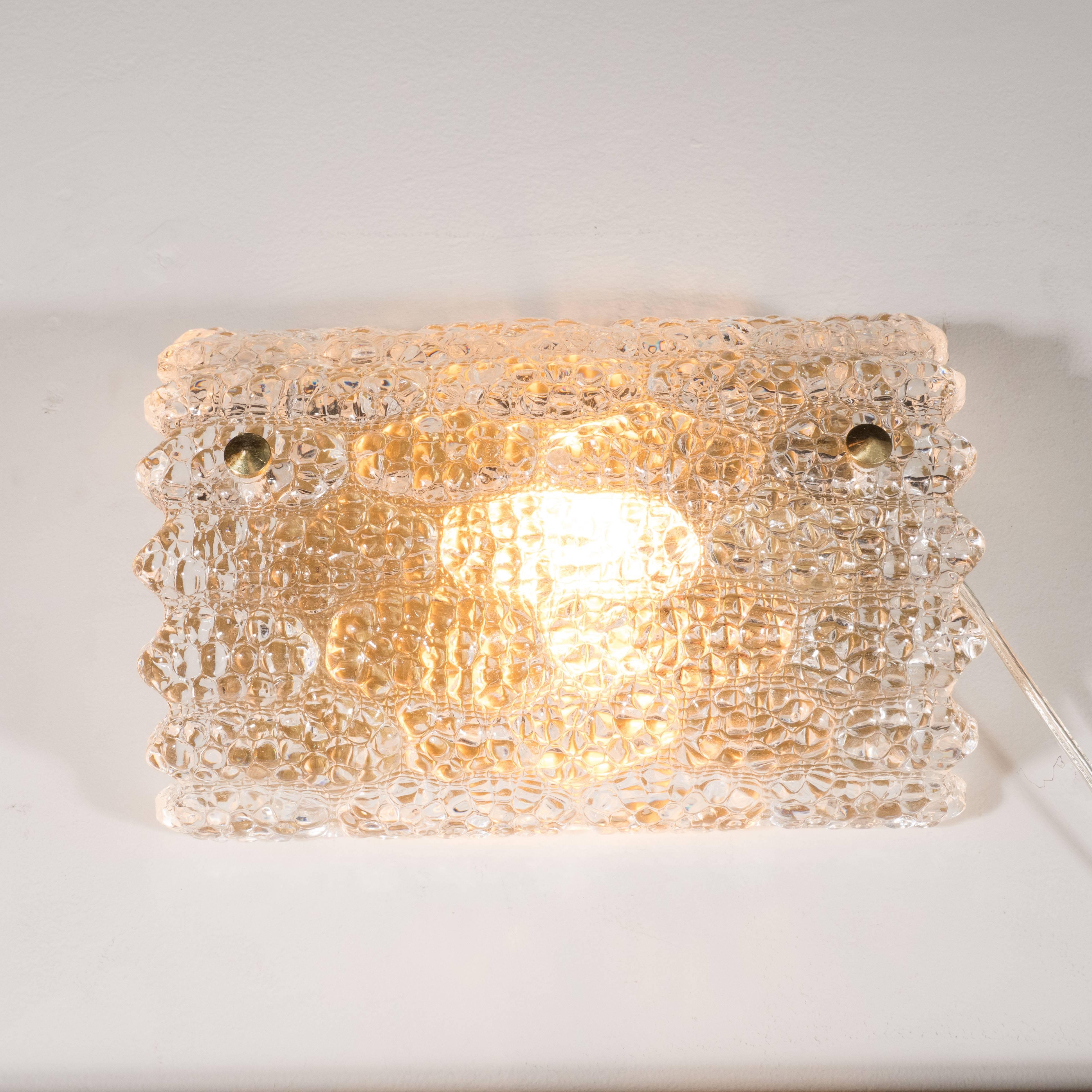 This Mid-Century Modernist vanity light by Carl Fagerlund for Orrefors features sophisticated organic, free-form design in a sculptural handblown textured glass shade mounted on brass fittings. This fixture holds (1) 100 watt Edison-base bulb. It