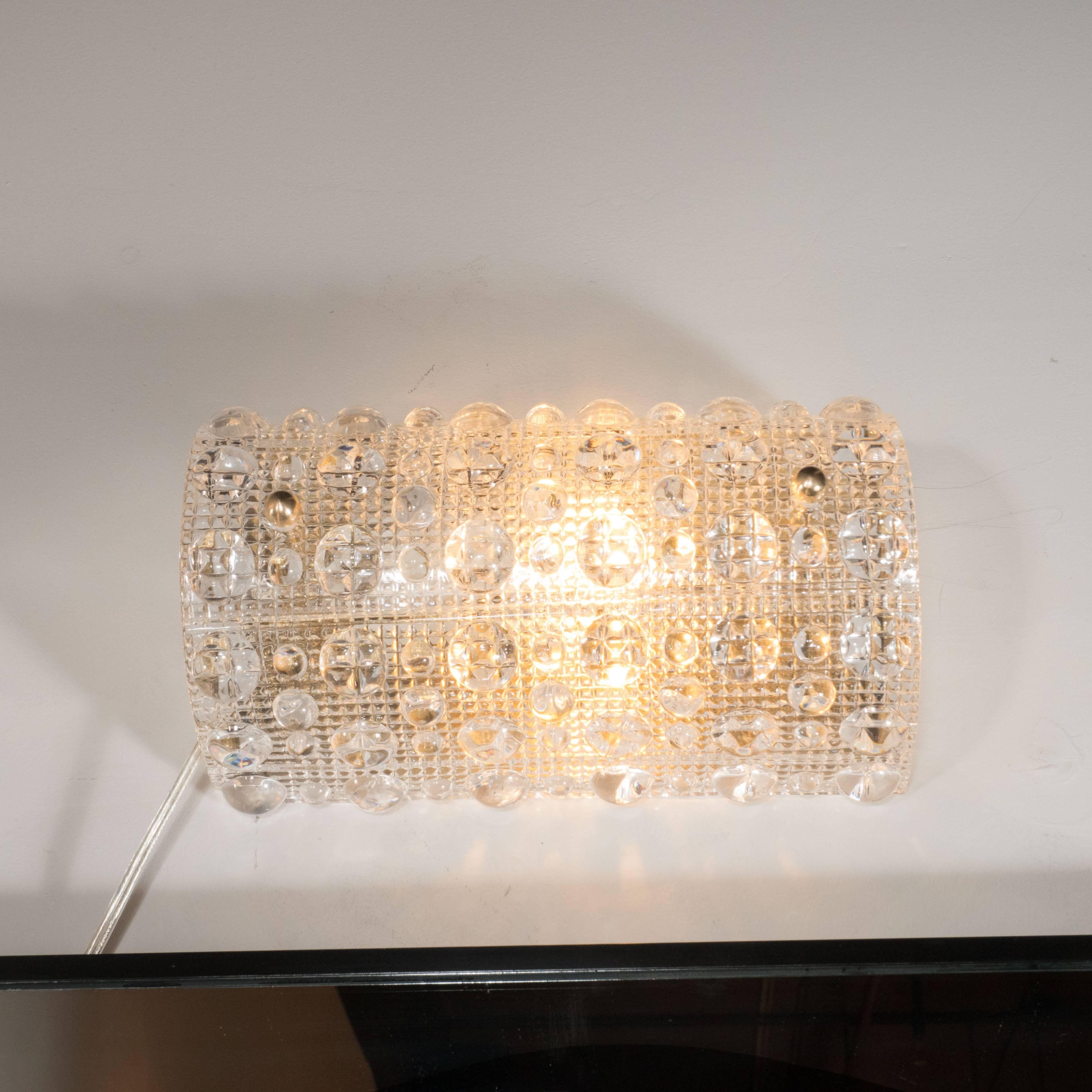 This Mid-Century Modernist vanity light by Carl Fagerlund for Orrefors features an elegant cross-hatch detail in a sculptural free-formed handblown textured glass shade mounted on brass fittings. This fixture holds (1) 100 watt Edison-base bulb. It