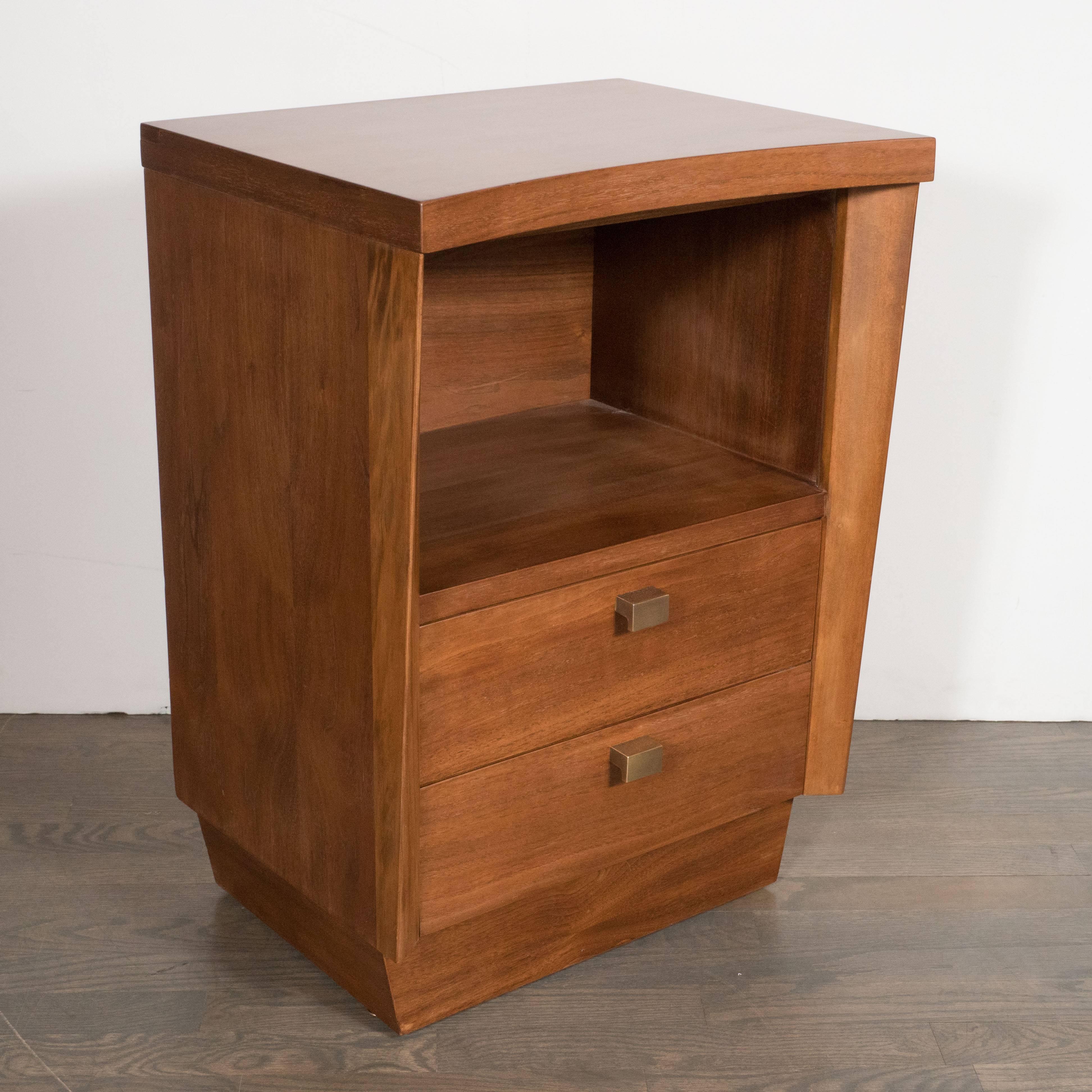 This stunning pair of nightstands in hand-rubbed walnut features a concave cut top, L-shaped brass pulls and integrated open shelves perfect for books or other precious items. The clean design and color palate, consisting of sumptuous polished brass