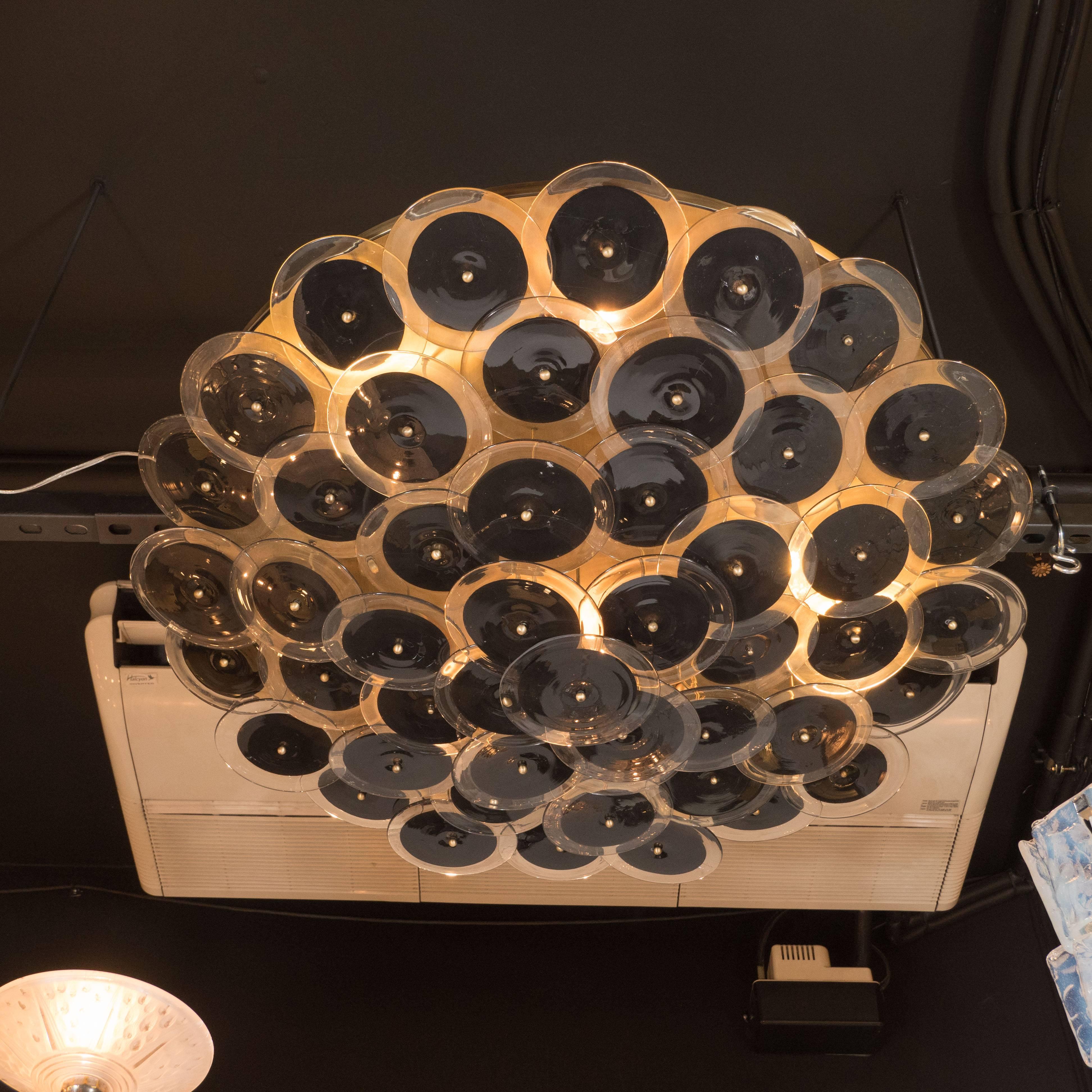Flush mount chandelier with handblown Murano black and clear glass discs. This flush mount chandelier consists of an array of numerous, individually attached handblown Murano clear glass discs that each incorporate a central opaque texture that is