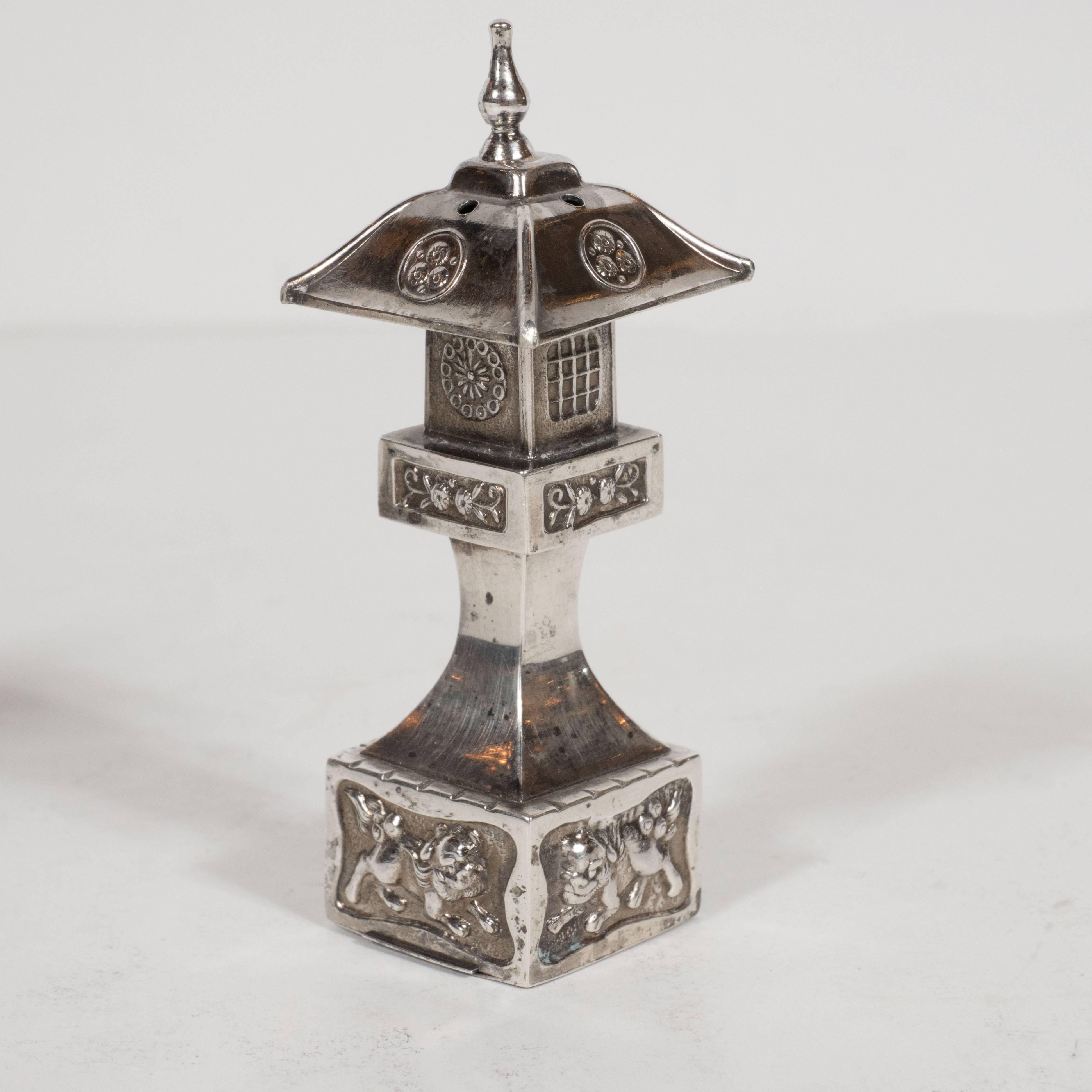 Composed of 25 grams of lustrous sterling silver, this pair of Pagoda style temple shakers feature decorative floral details and guardian lions inscribed at the base a traditional motif in Chinese temple architecture. They also boast a delicate