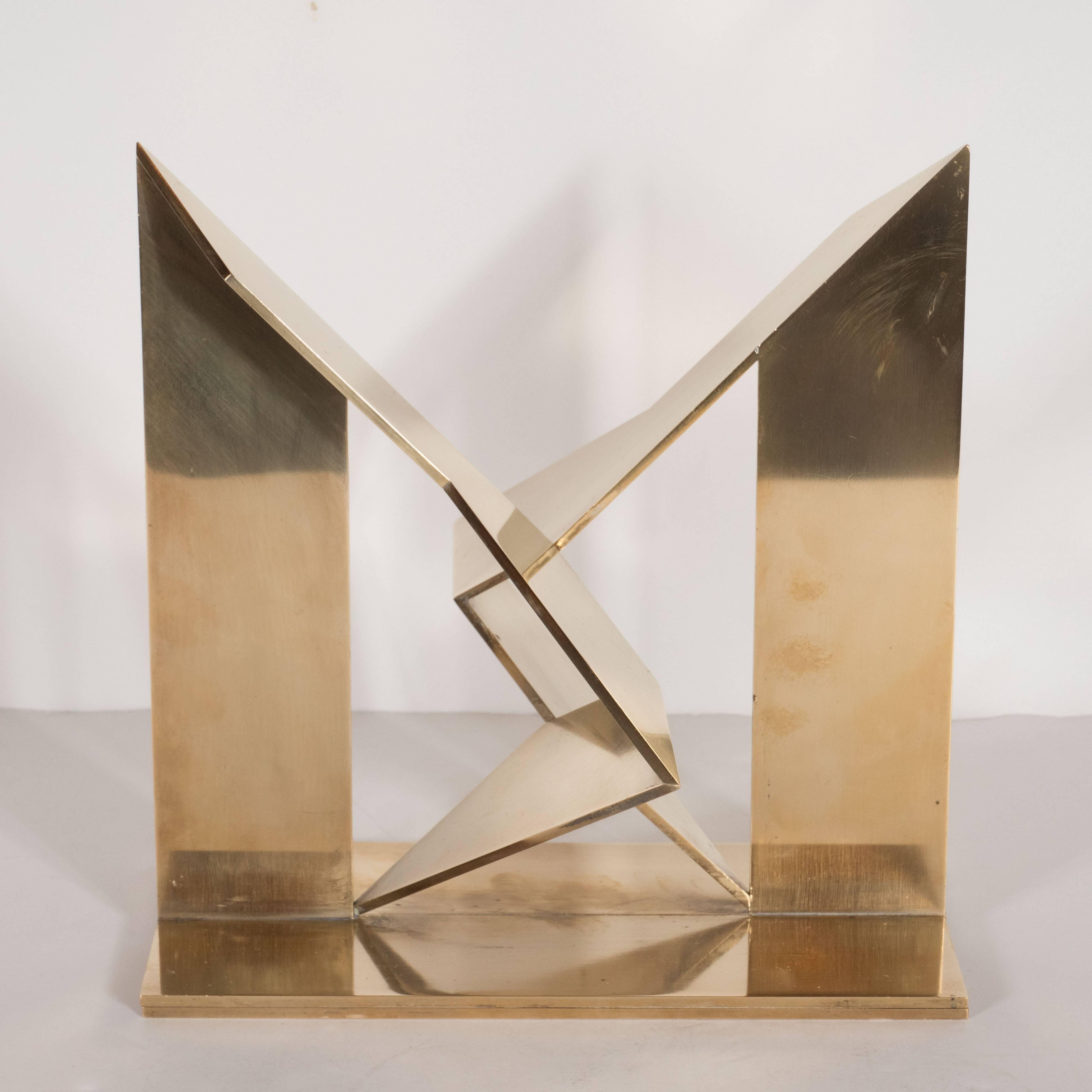 This lustrous brass sculpture features two geometric forms in palendromic symmetry that kiss at the center of the plinth. Mathias Goeritz (b. 1917, Germany), the esteemed Mexican artist, realized this dynamic sculpture in 1978. The excellence of his