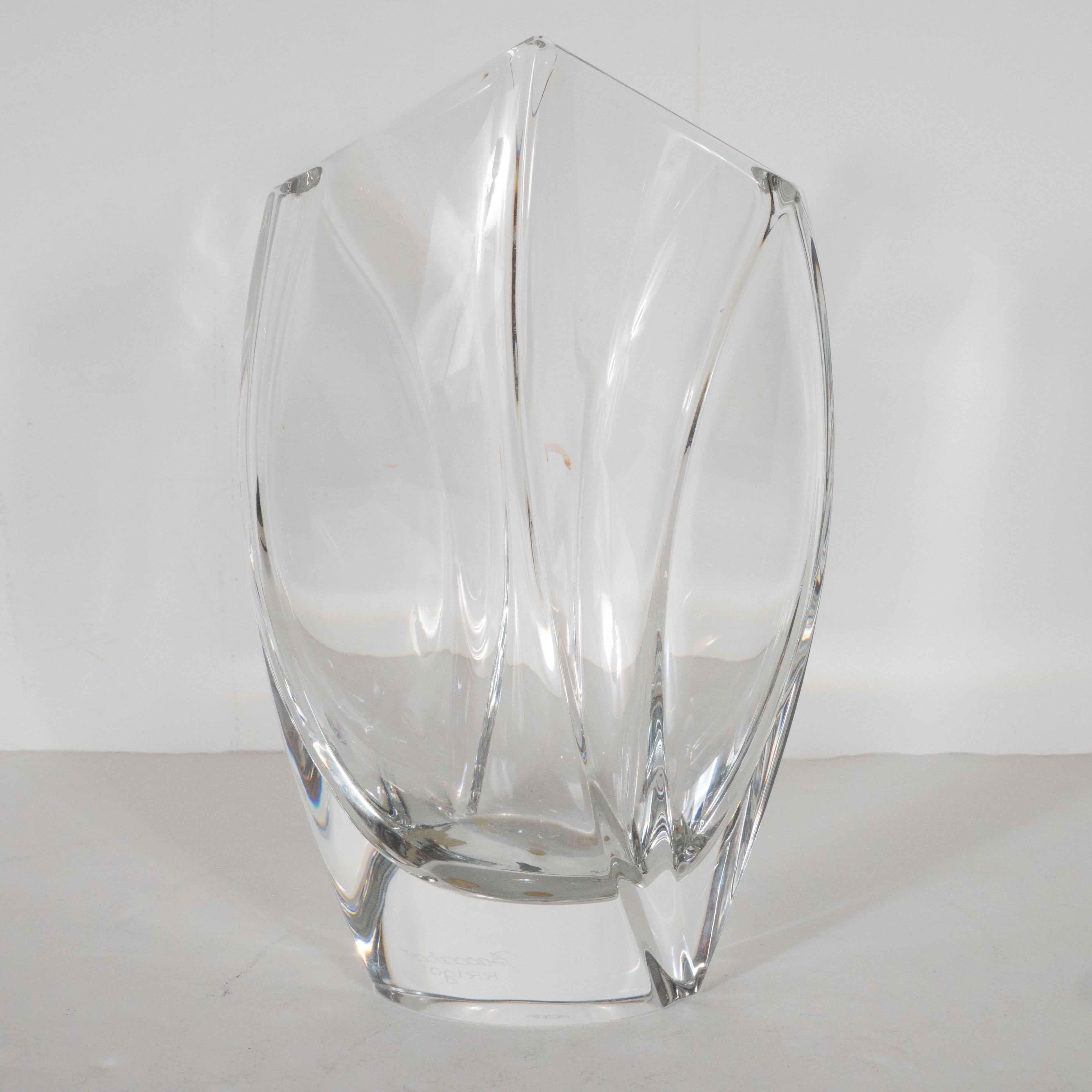 This gorgeous vase was designed by the illustrious French designer Robert Rigot and realized by Baccarat- arguably the world's premiere crystal maker, circa 1980. It features modernist curved forms cut into the glass and a sloped top that comes to