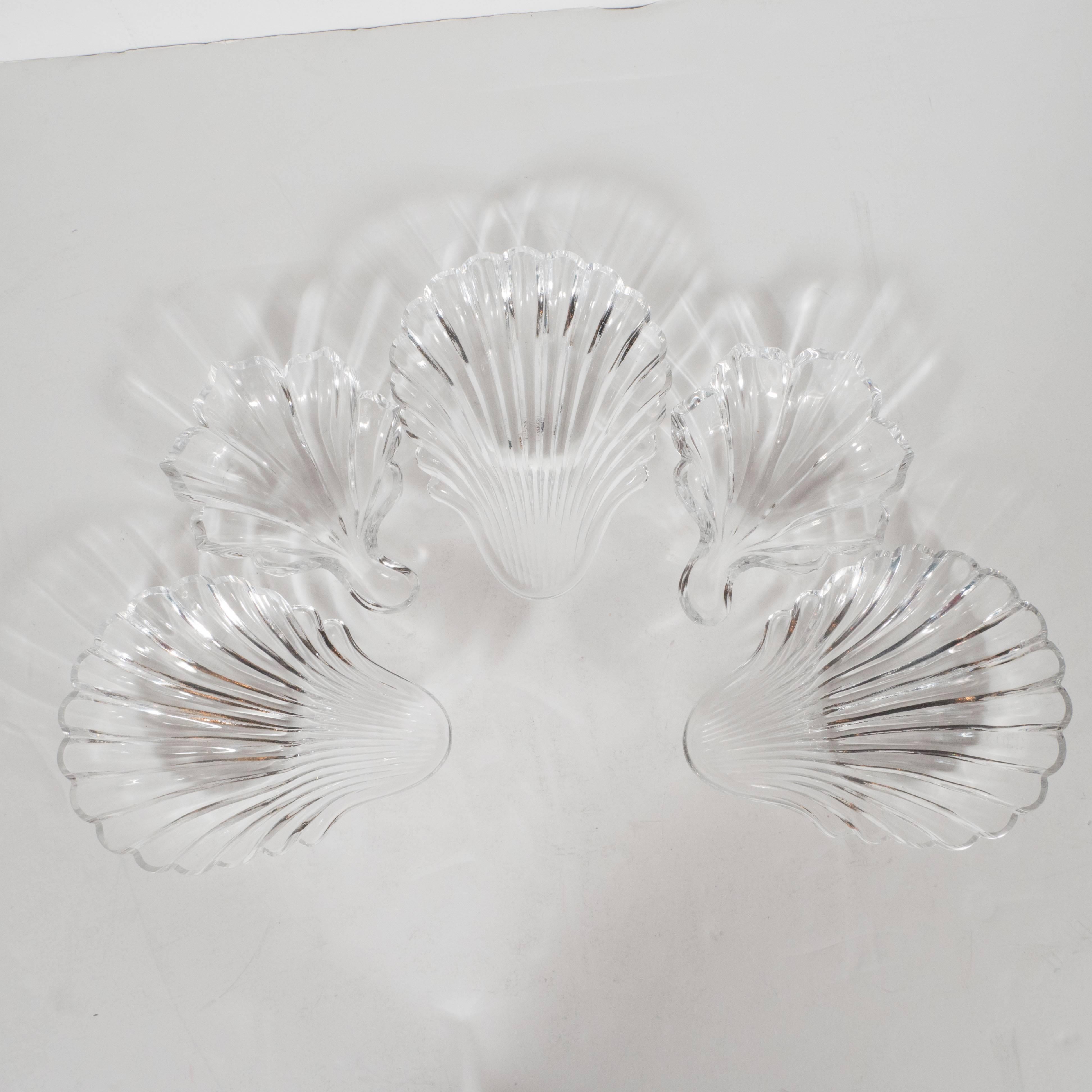 This stunning set of nut and condiment bowls were created by Baccarat, one of the world's most illustrious crystal companies- in France, circa 1960. The set is comprised of five bowls in total- three larger ones and two smaller ones. The larger