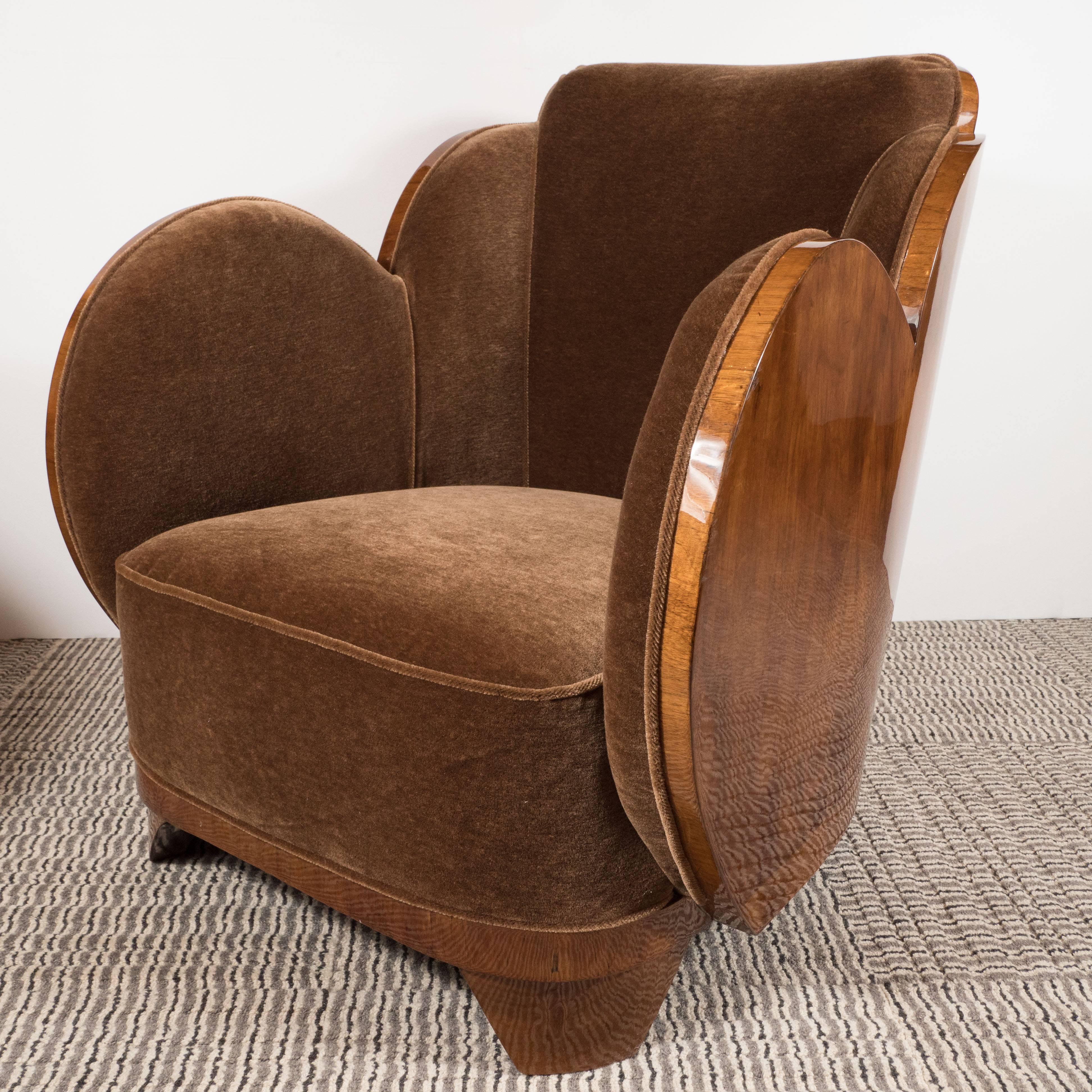 This streamline pair of "Cloud" series Art Deco club/arm chairs feature elegant undulating curves of book matched walnut, tapered pentagonal feet, and luxurious mohair in a smoked topaz hue. These chairs define both old world decadence as