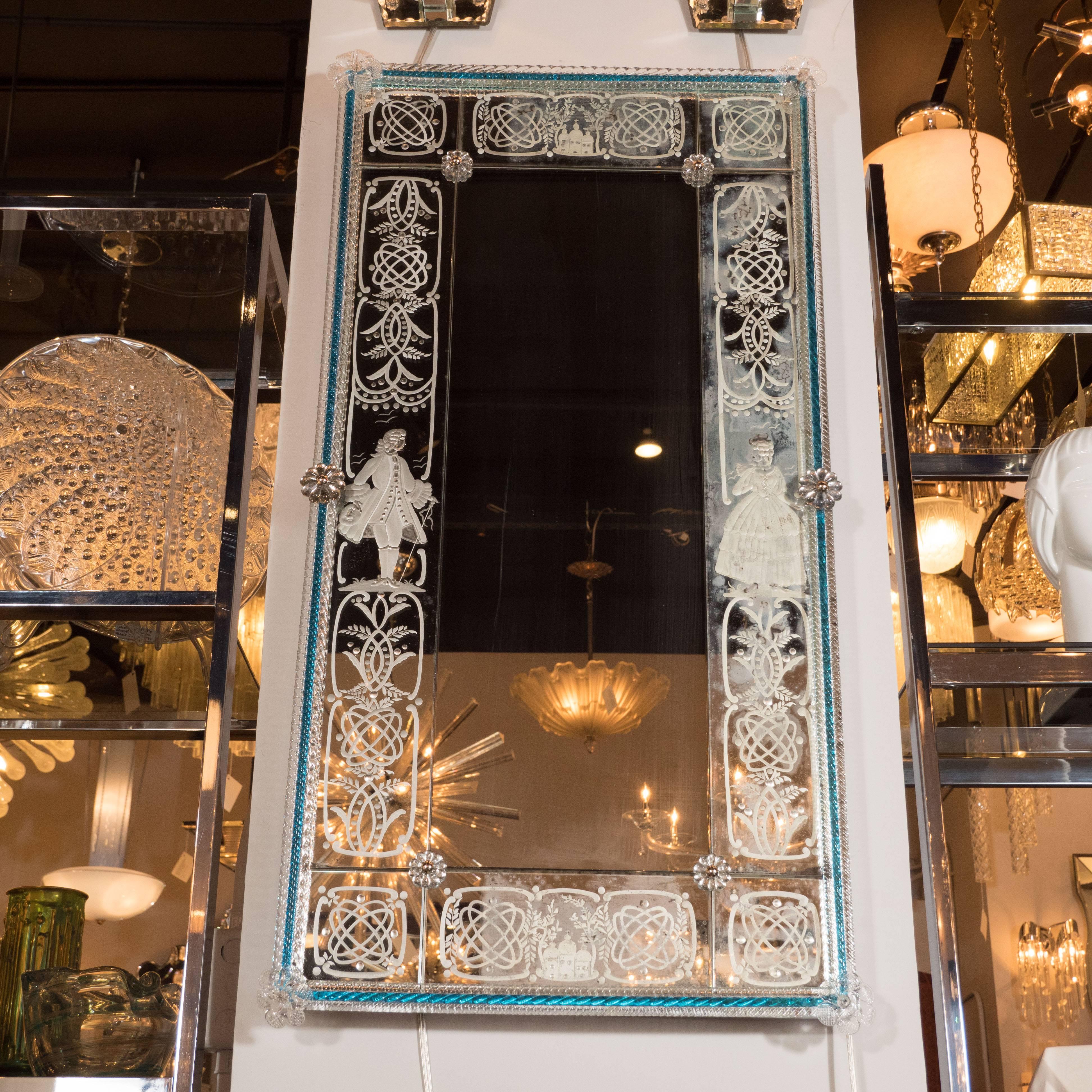 This gorgeous mirror was handcrafted by artisans in Venice in the mid-1920s. It features Murano applique and reverse etched foliate and geometric patterns throughout. In the center top and bottom panels, there are three church buildings crowned with