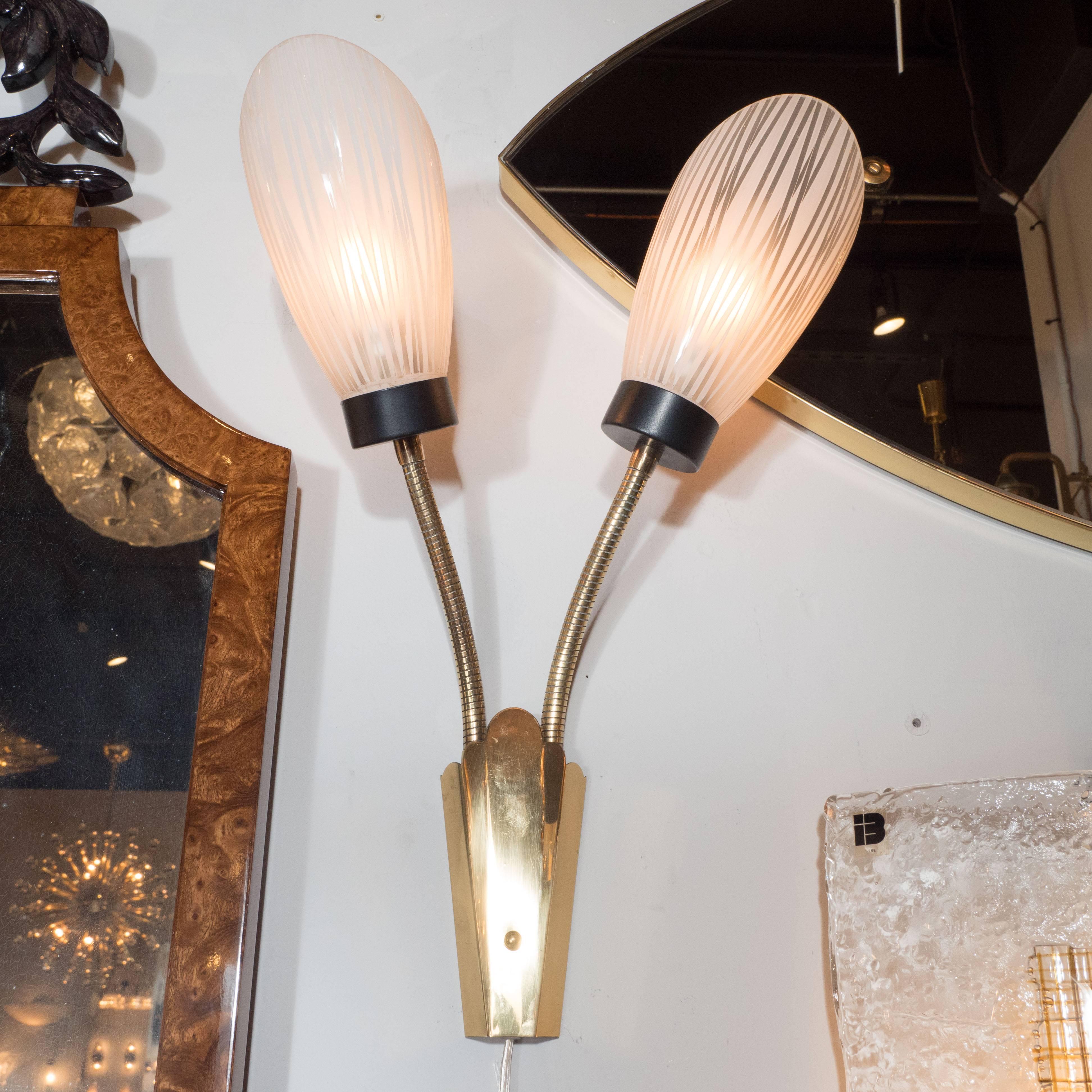 This exquisite set of six Art Deco Modernist petal sconces features two adjustable brass arms each extending from lustrous brass skyscraper style bases. The frosted shades have been painted with white pigment to create a striated reeded pattern, and
