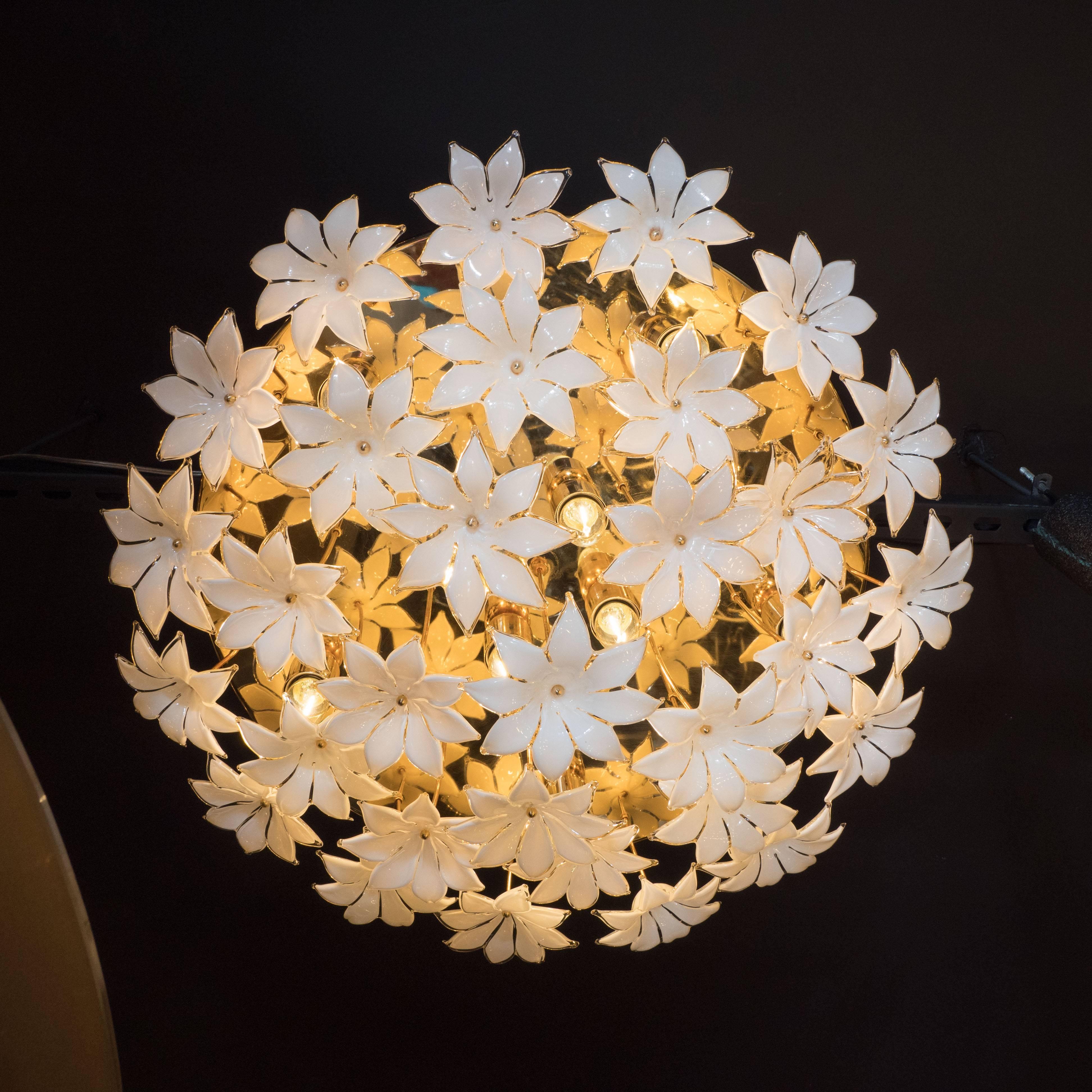 This vibrant Mid-Century Modernist flush mount chandelier features an explosion of daffodil shaped shades attached to a circular polished brass base by lustrous brass rods. The shades were meticulously crafted, by hand, on the fabled Venetian Island