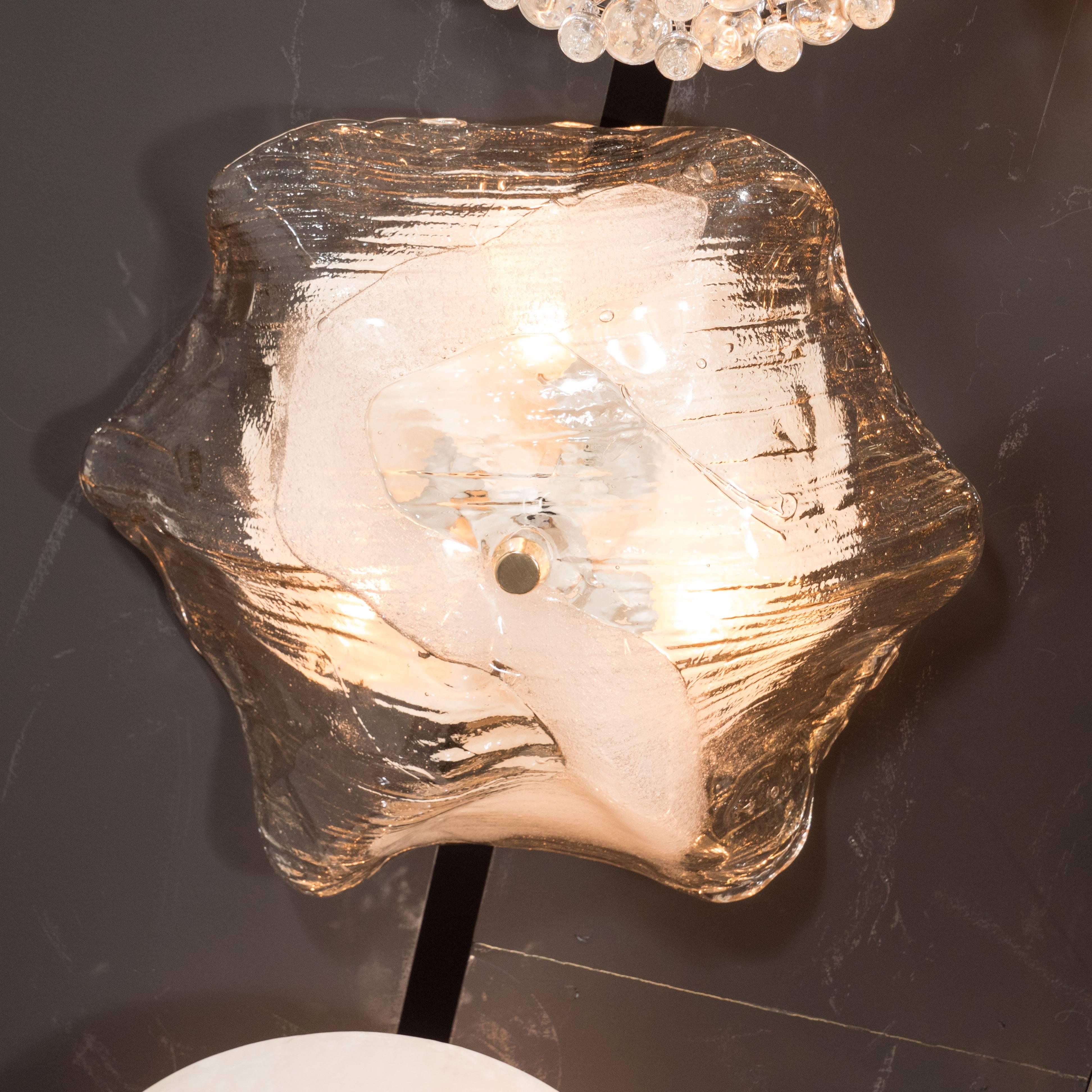 This sophisticated handblown Mid-Century Modernist handblown glass flush mount is composed of translucent smoked glass with a subtle striated pattern, effervescent bubbles, and a s-shaped embellishment in opaque white glass. It was produced in