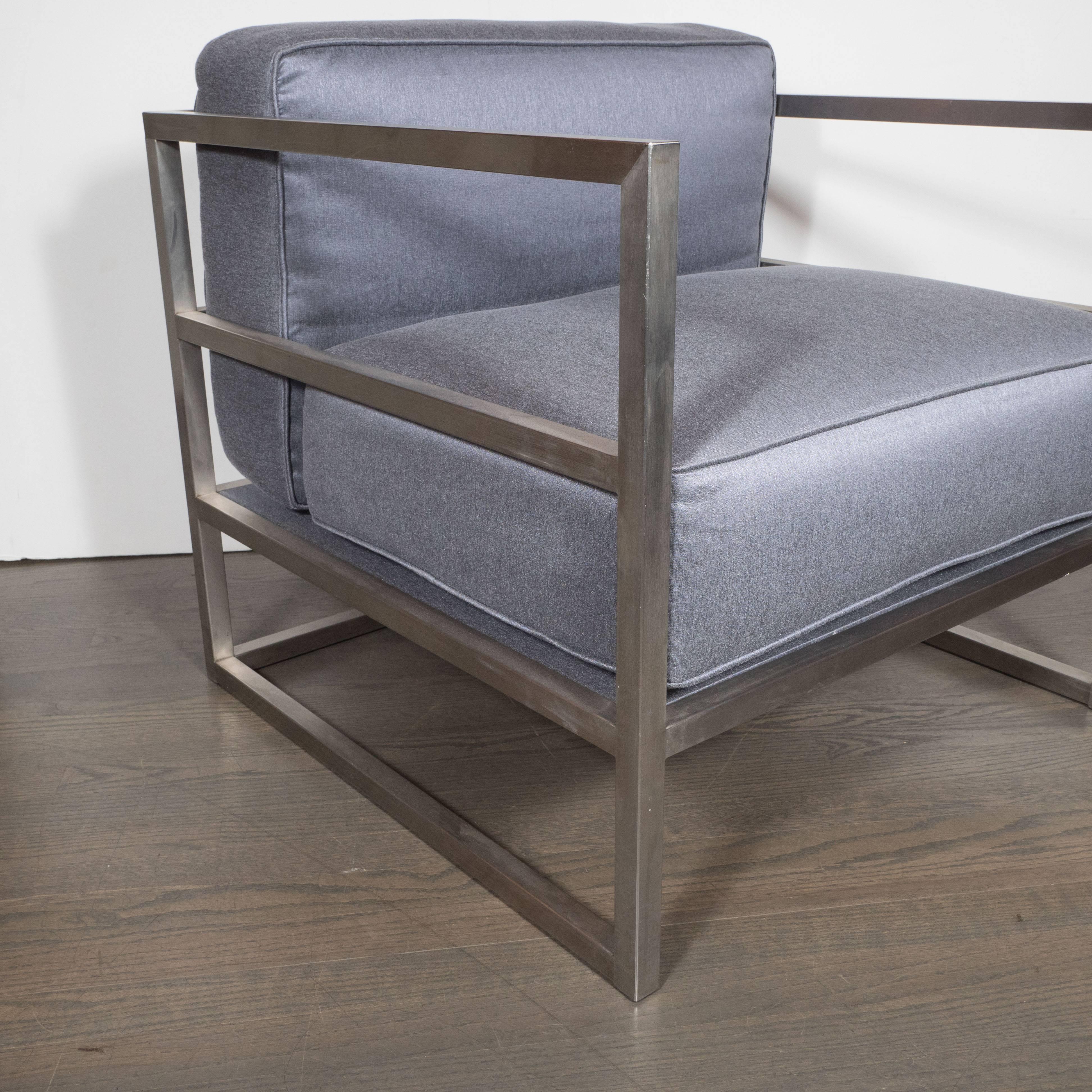 This pair of lounge/club chairs features a Minimalist frame consisting of four horizontal beams intersected perpendicularly at the corners by posts to form a three sided cube. The structure has been handcrafted in forged and brushed aluminium. The