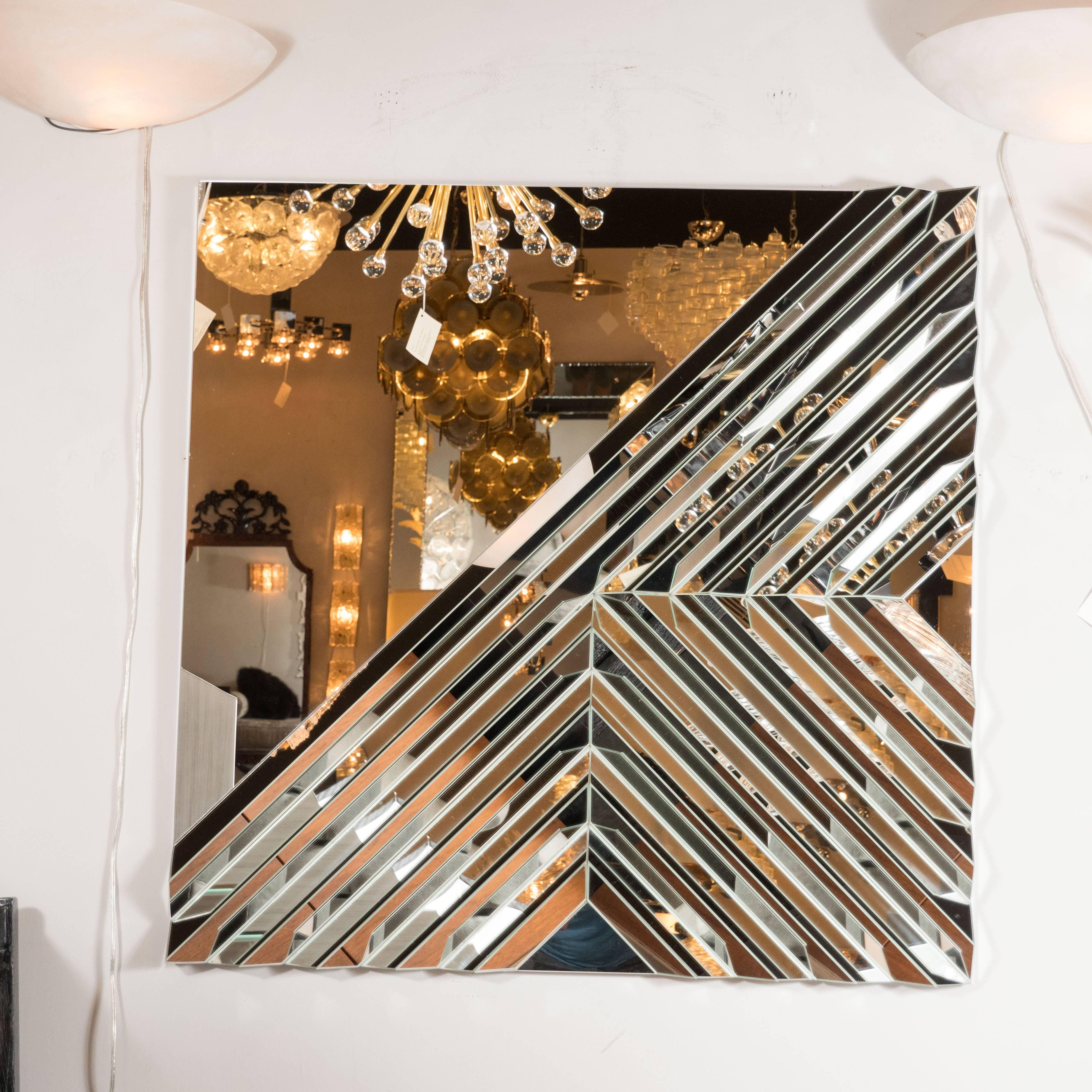 This custom mirror, featuring a wealth of geometric designs in relief was handmade by our exclusive atelier. It features to symmetrical Chevron patterns- one from the bottom of the frame and the other from the right side- that meet in the center to