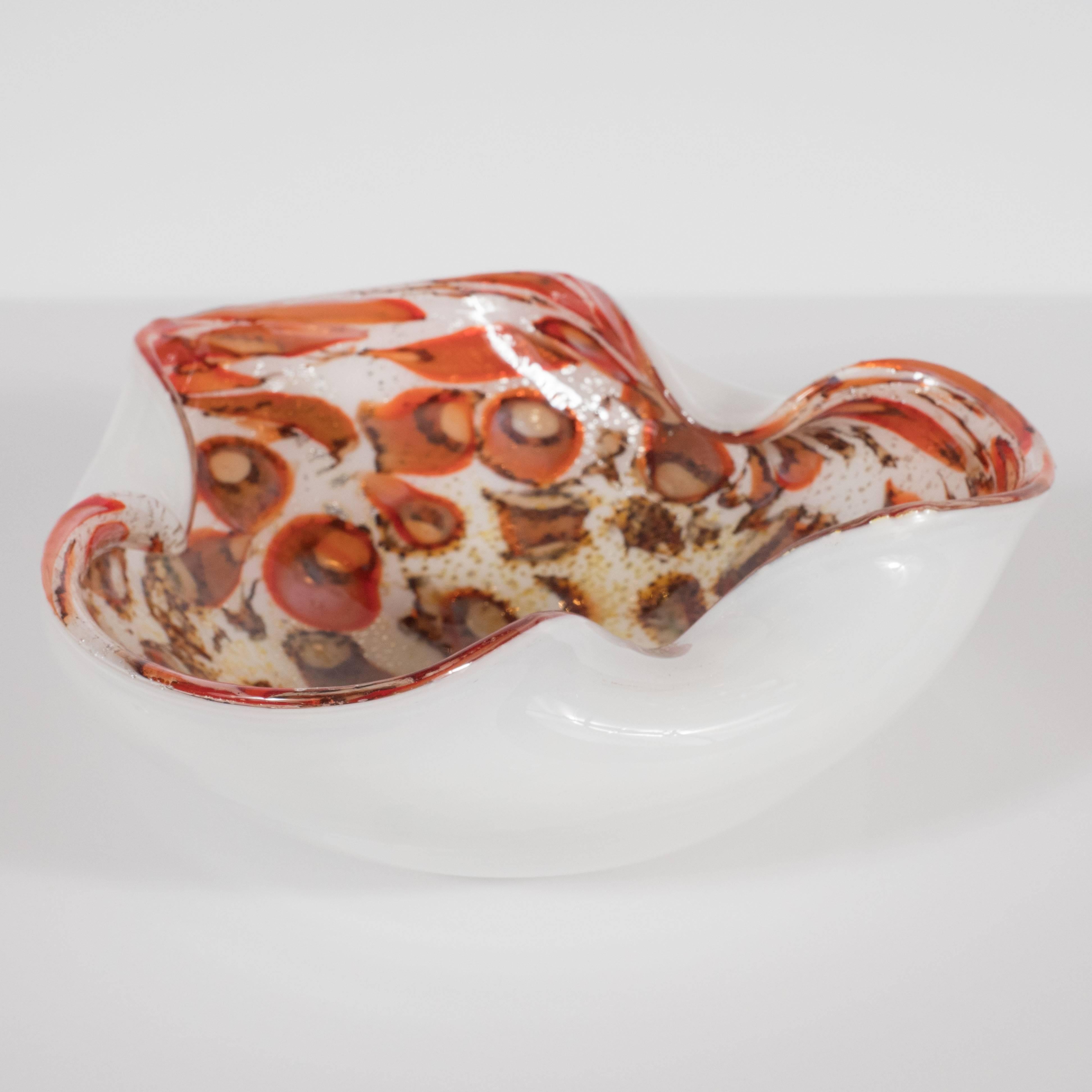 This dynamic Mid-Century Modern bowl was hand blown on the fabled island of Murano, Italy, off the coast of Venice renowned for centuries for its superlative glass production. This piece features flowing and sinuous curves achieved by three gently