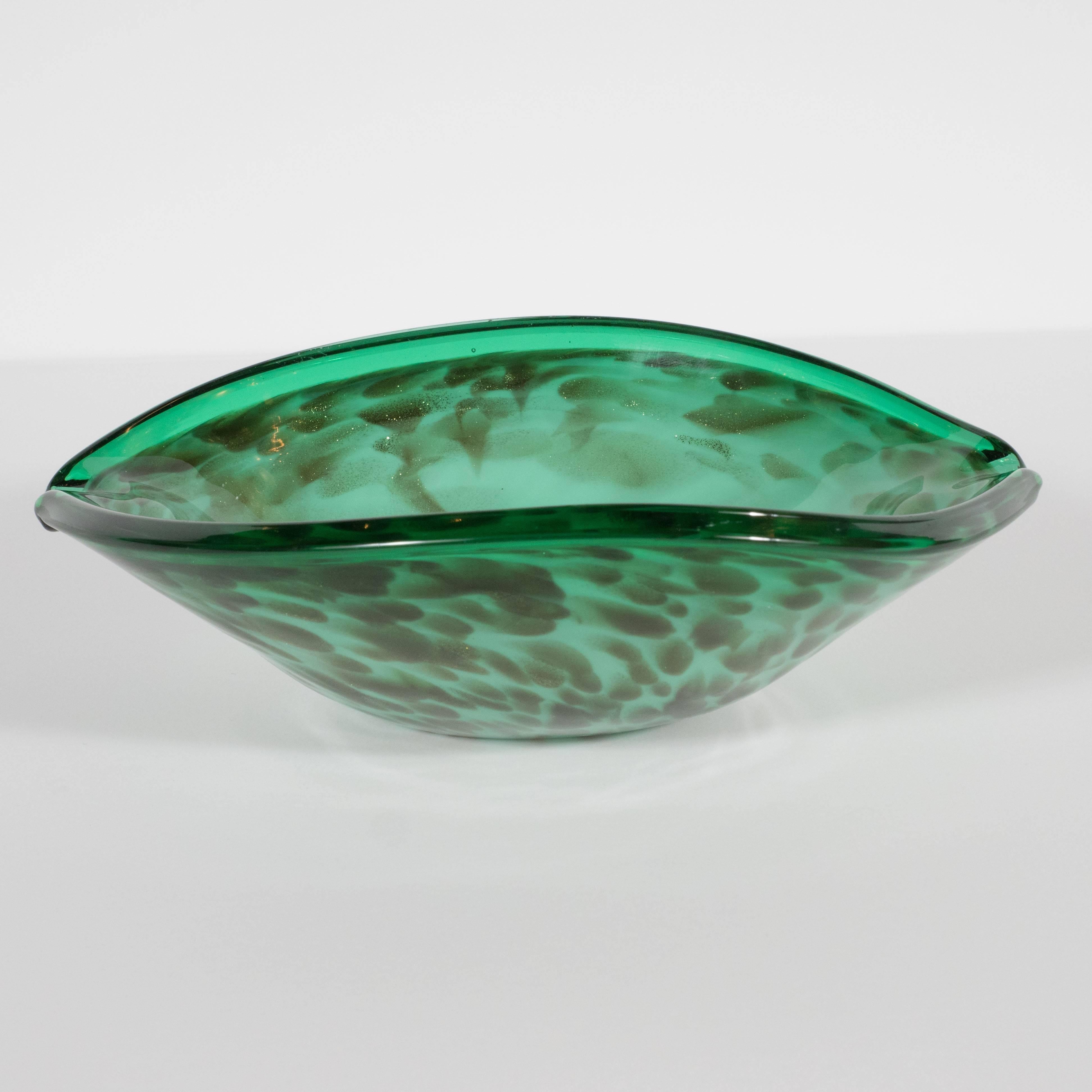 This stunning Mid-Century Modern glass bowl was handblown on the fabled Venetian island of Murano a locale internationally renowned for its superlative artisanal glass for centuries, circa 1950. The body of the piece, resembling the shape of an